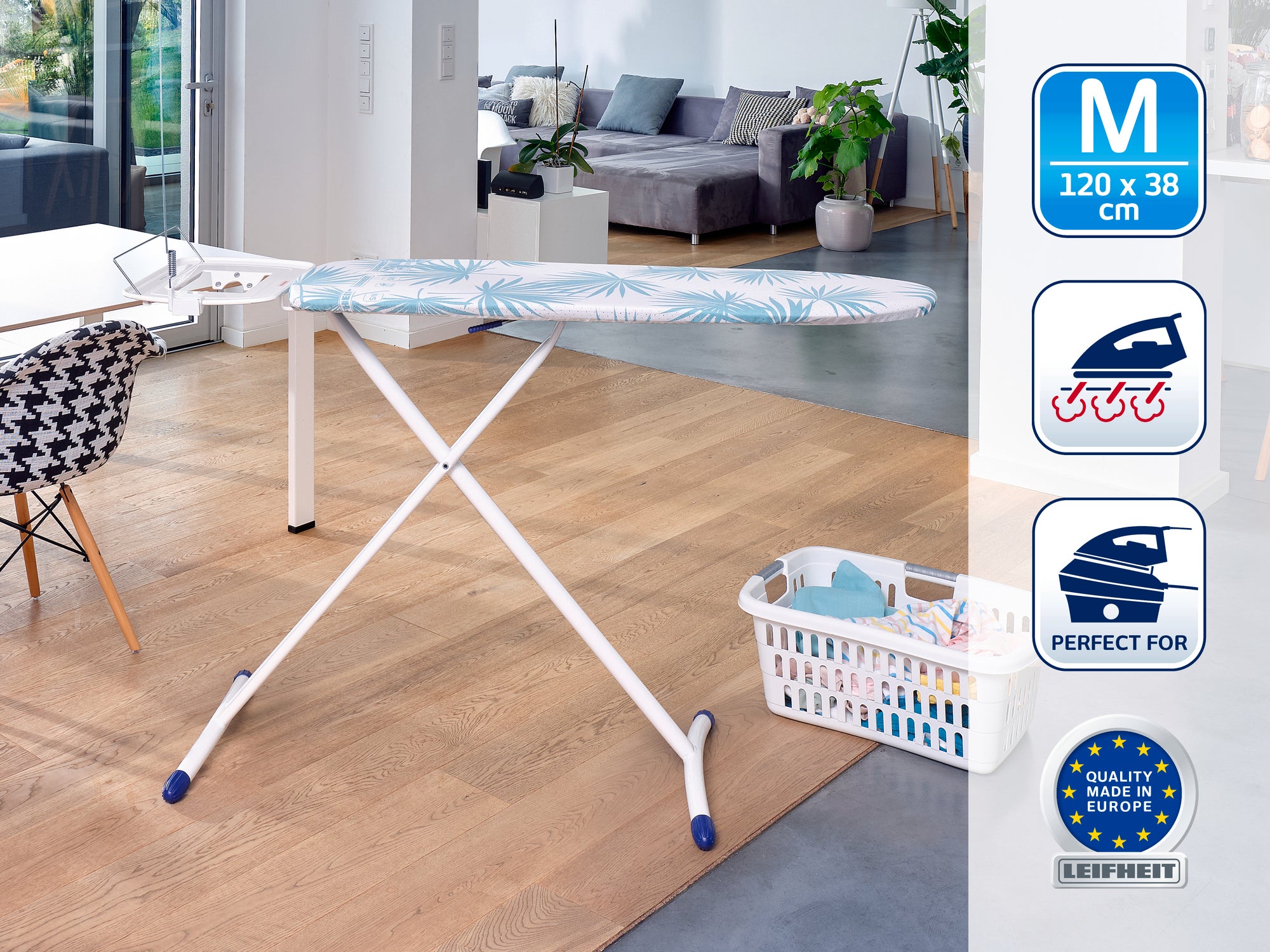 Table à repasser moderne dans un salon lumineux. La table a une surface bleue à motifs et se trouve à côté d'un panier à linge. Idéale pour un repassage efficace.