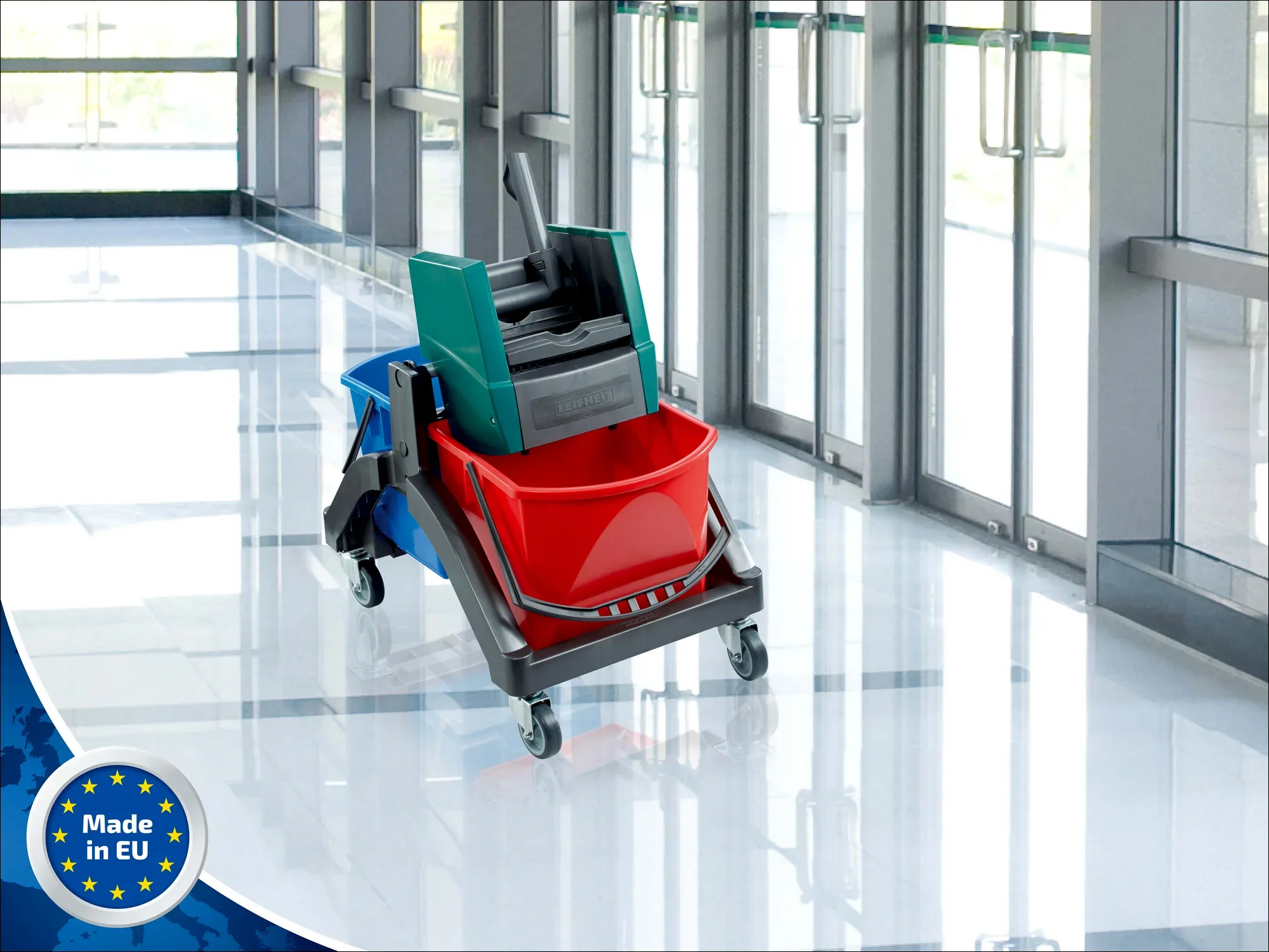 Leifheit Professional Nasswischer Duo im Einsatz auf einem glänzenden Boden in einem modernen Gebäude. Der Wischer hat zwei Eimer in Rot und Blau und ist mit Rollen ausgestattet.