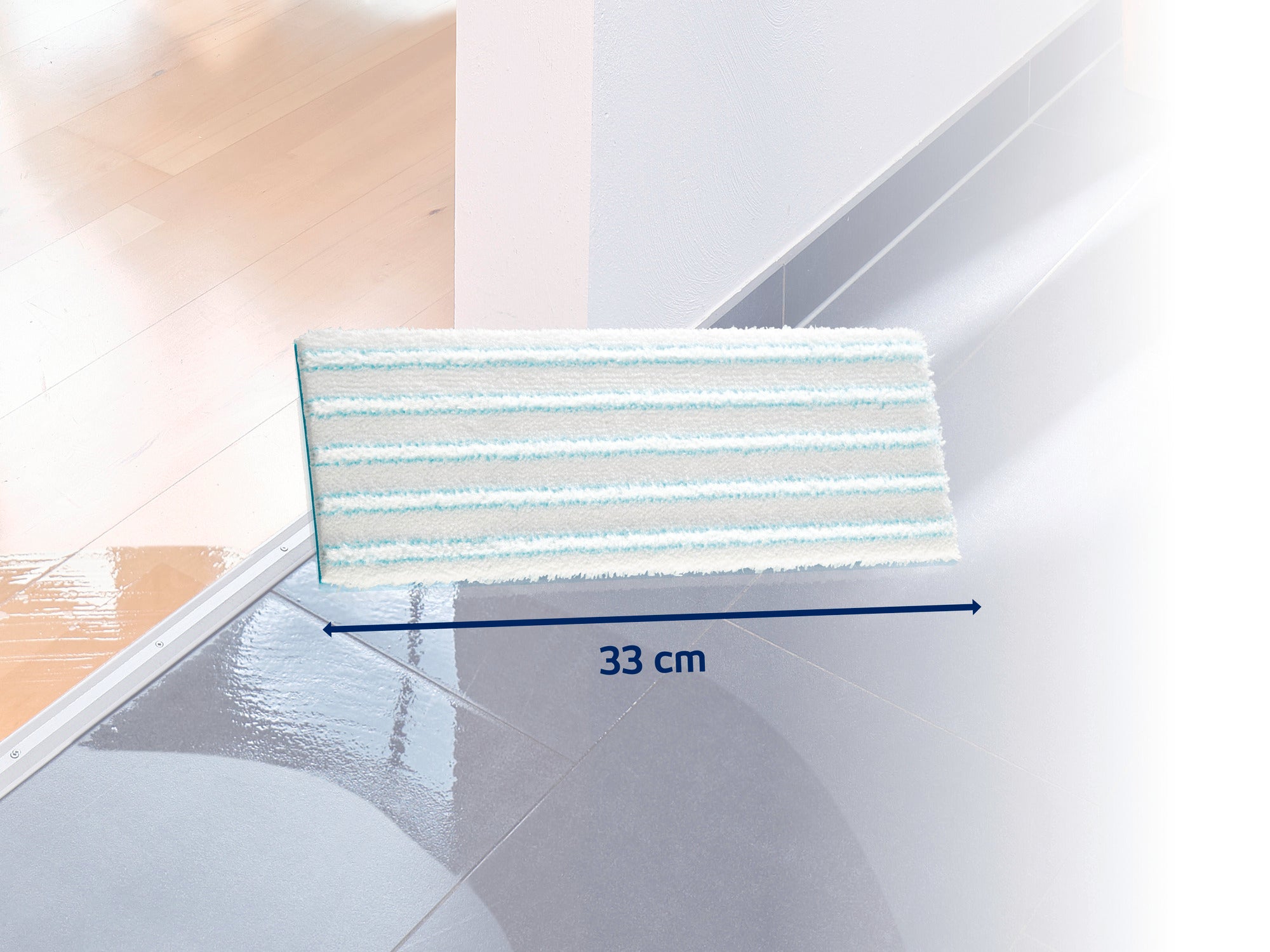Ein rechteckiger Wischmopp-Aufsatz mit einer Breite von 33 cm liegt auf einem glänzenden Boden. Der Aufsatz hat weiße und hellblaue Streifen und ist ideal für die gründliche Reinigung von Hartböden.