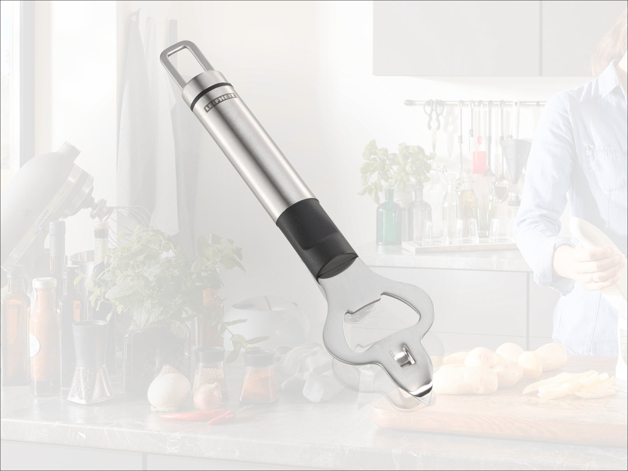 Ouvre-bouteille en acier inoxydable avec poignée ergonomique, idéal pour un usage quotidien dans la cuisine. En arrière-plan, on aperçoit une cuisine moderne avec des ingrédients frais.