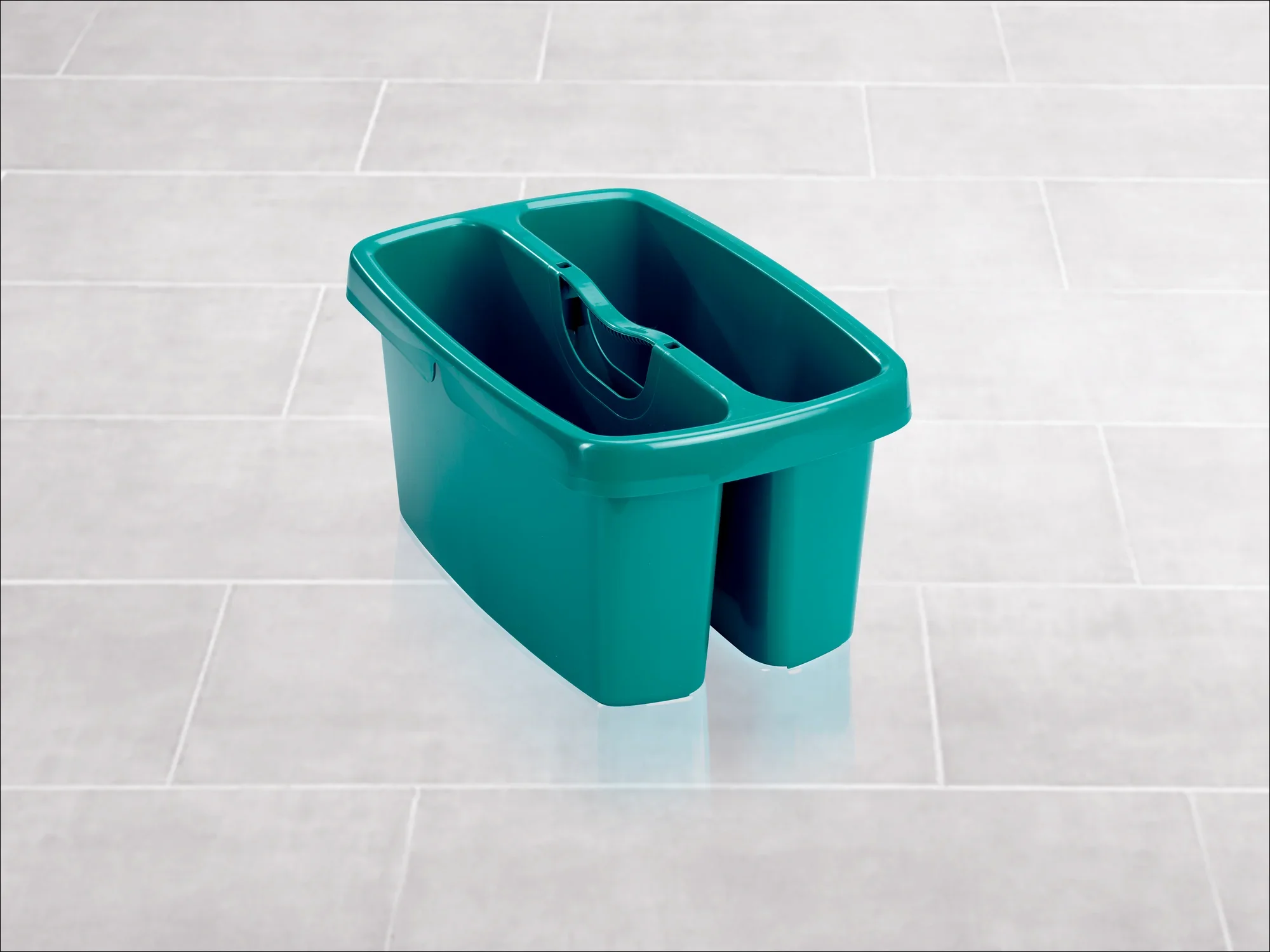 Een groene emmer met twee compartimenten staat op een lichtgekleurde tegelvloer. De emmer is robuust en ideaal voor schoonmaaktaken in verschillende omgevingen.