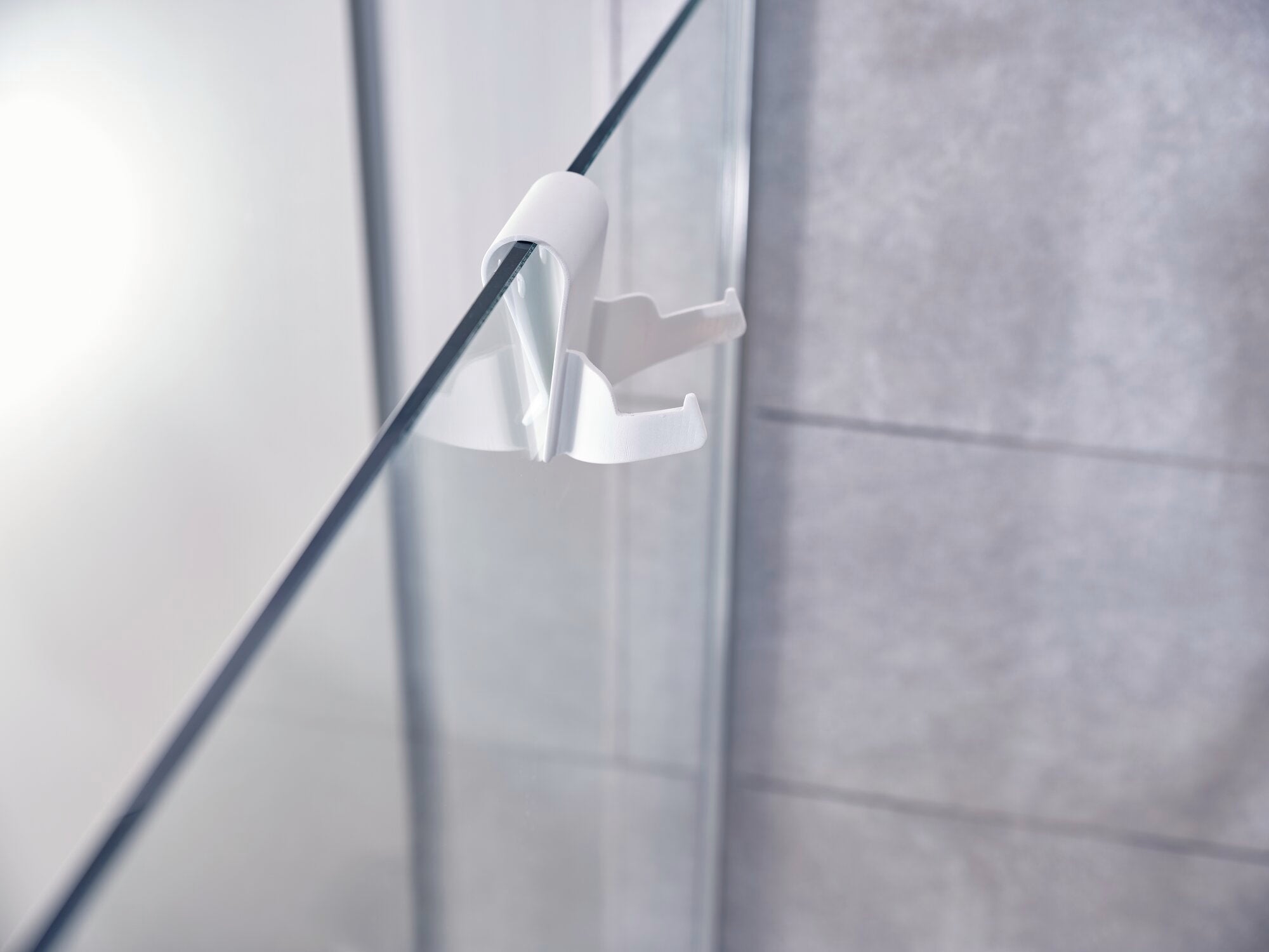 Ein Fenster- und Badsauger "Nemo" der Marke Leifheit ist an einer gläsernen Duschwand angebracht. Das Gerät sorgt für streifenfreie Sauberkeit und verhindert Kalkablagerungen.