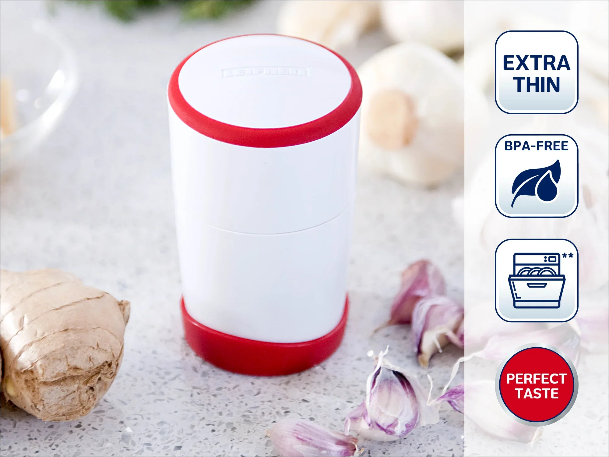 Een witte, cilindervormige keukenhulp met rode rand staat op een werkblad, omringd door knoflook en gember. Symbolen tonen: extra dun, BPA-vrij, vaatwasmachinebestendig, perfecte smaak.
