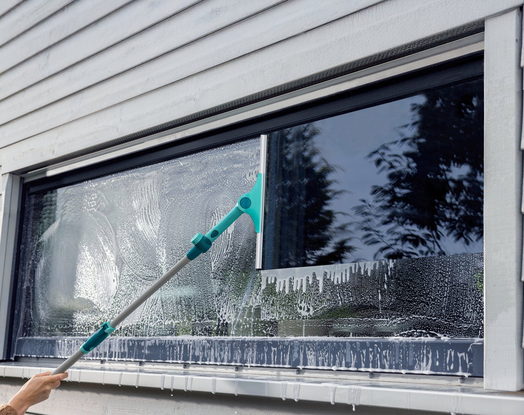 Een raam wordt gereinigd met de WindowSlider 2in1 XL ProReach Telescopic. De slider bereikt moeiteloos hoge plekken en zorgt voor streeploos schoon.