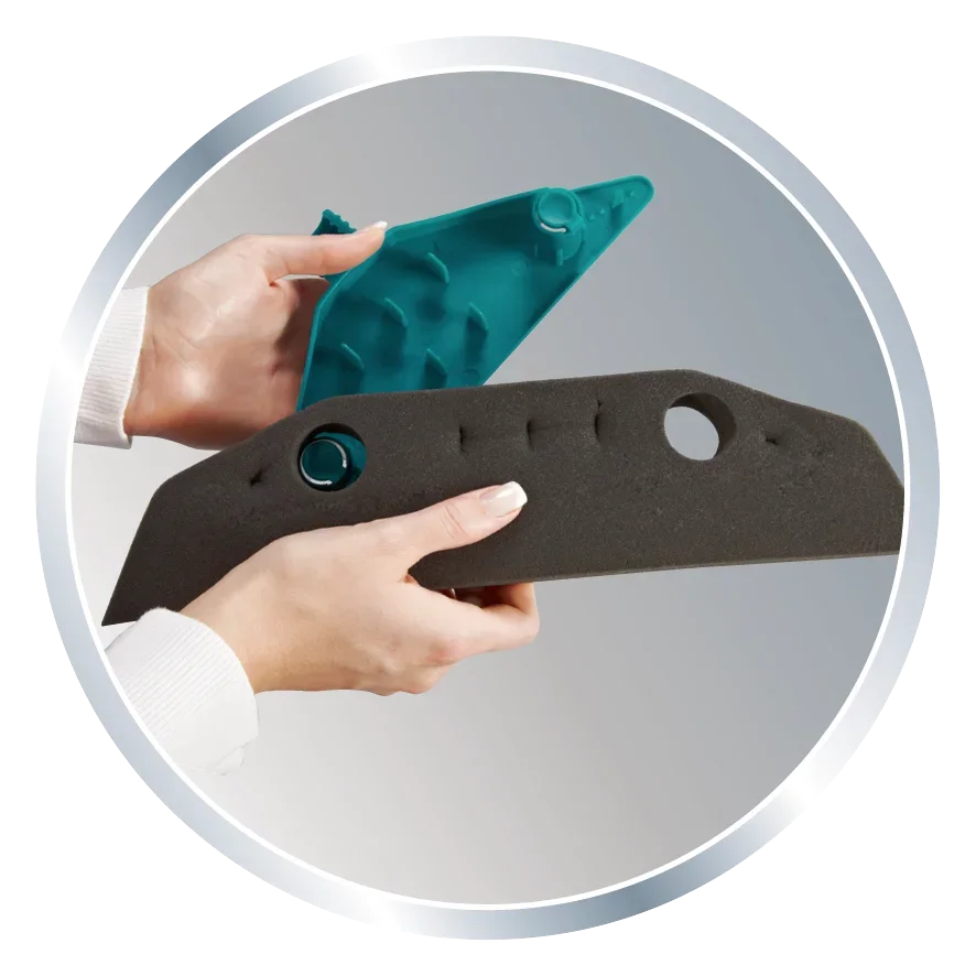 Twee handen houden het vervangende Soft&Easy schuim vast. Het schuim is zwart met ronde uitsparingen en wordt gepresenteerd naast een blauw plastic onderdeel.