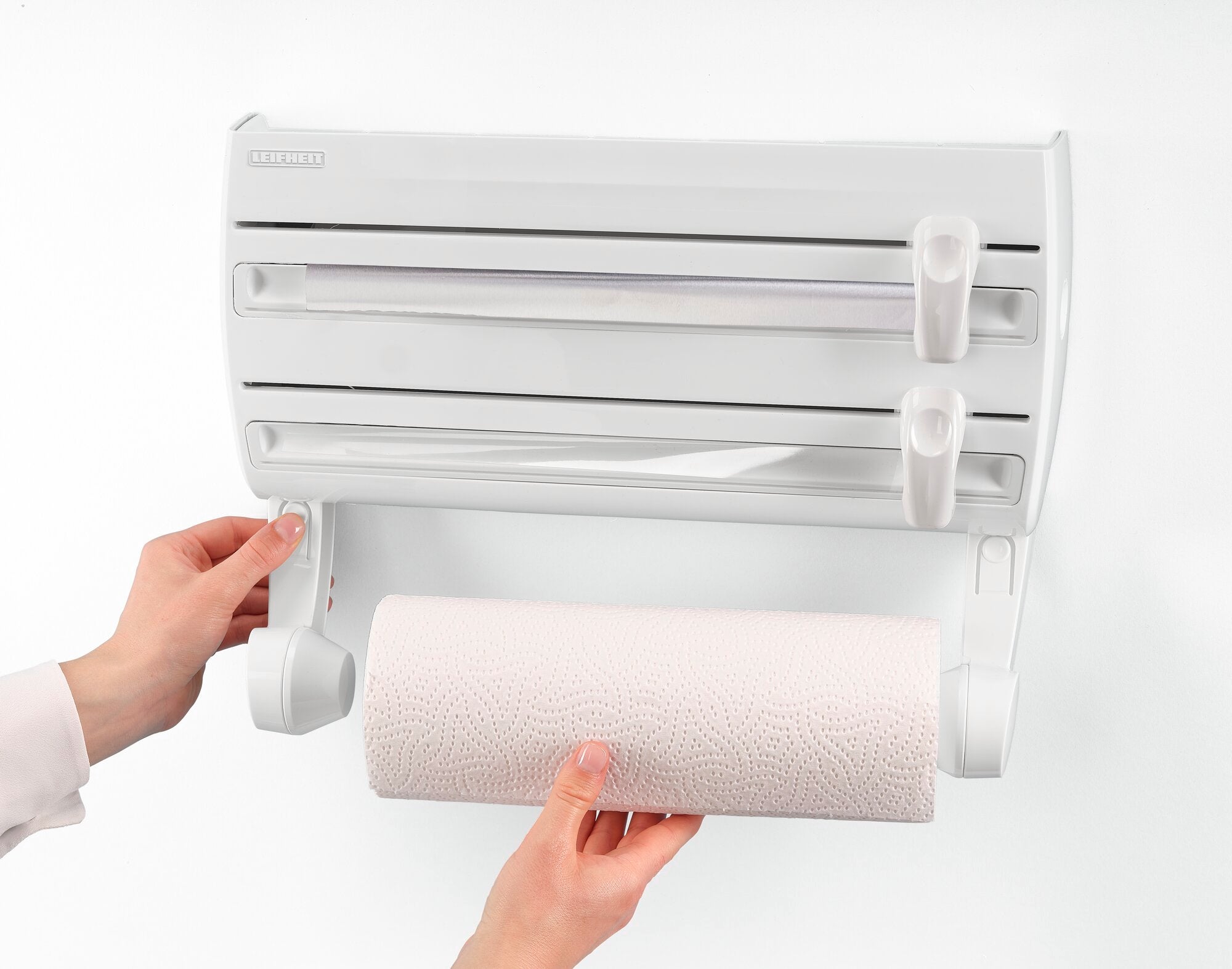 Wandrollenhalter Parat F2: Eine Person montiert eine Küchenpapierrolle in einen weißen Wandrollenhalter mit zwei zusätzlichen Halterungen für Folien. Ideal für die Küche.