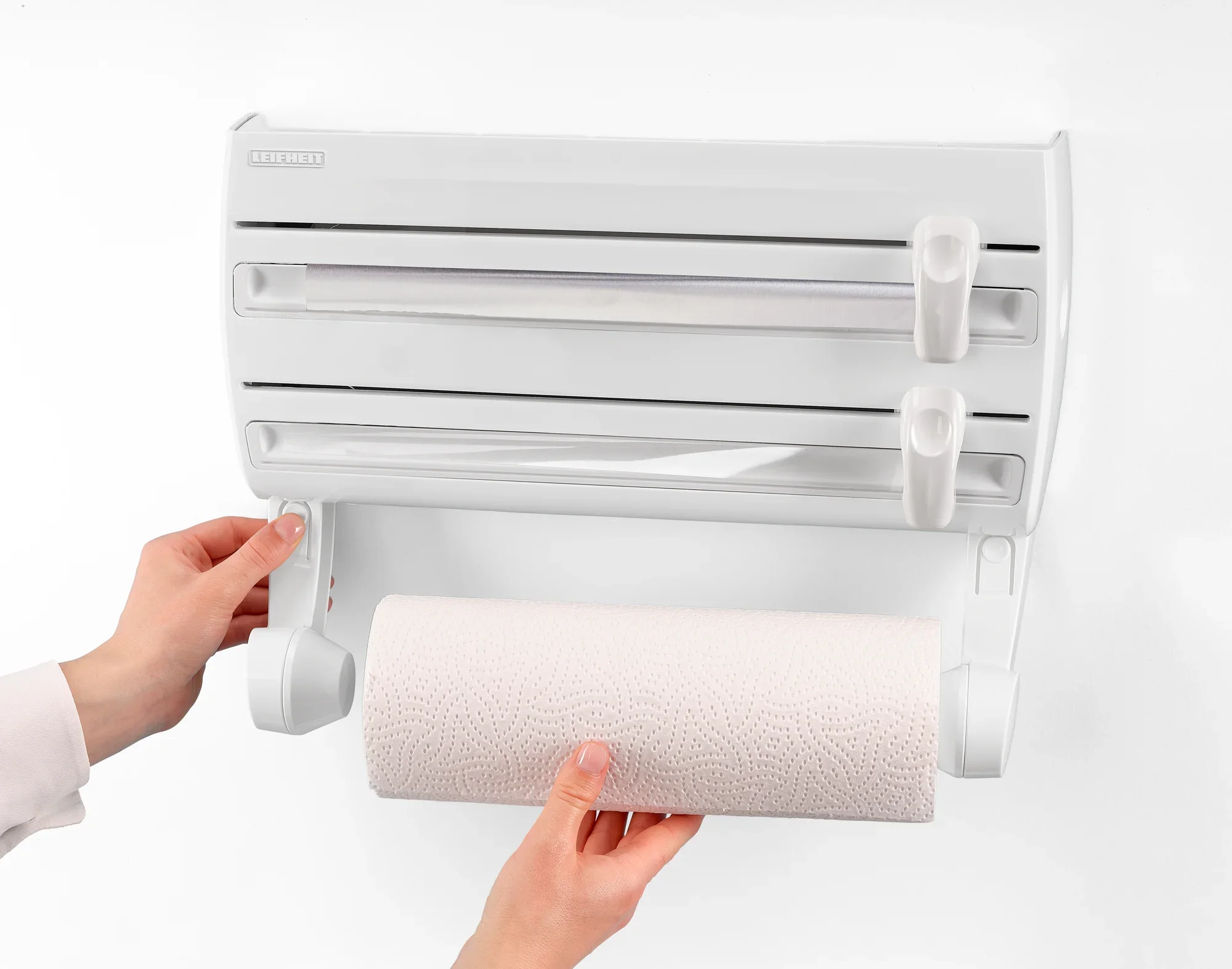 Portarotolo da parete Parat F2: una persona monta un rotolo di carta da cucina in un portarotolo da parete bianco con due supporti aggiuntivi per pellicole. Ideale per la cucina.