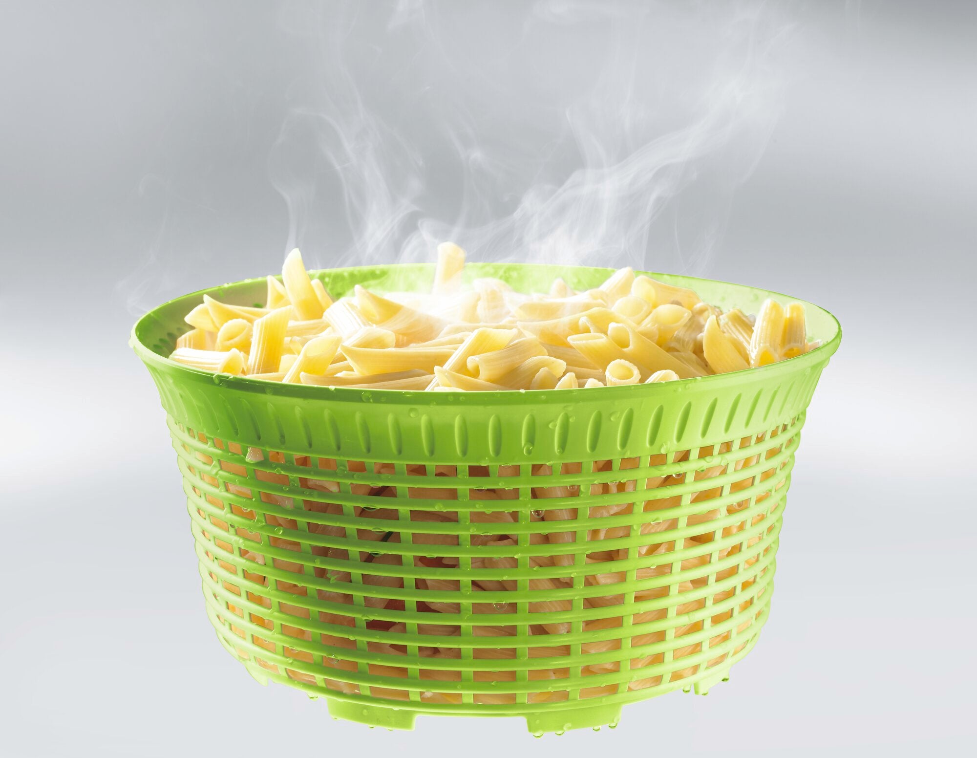 Grüne Salatschleuder mit einem Fassungsvermögen von 5,5 Litern, gefüllt mit dampfenden Nudeln. Ideal zum Abtropfen und Trocknen von Salat oder Pasta.