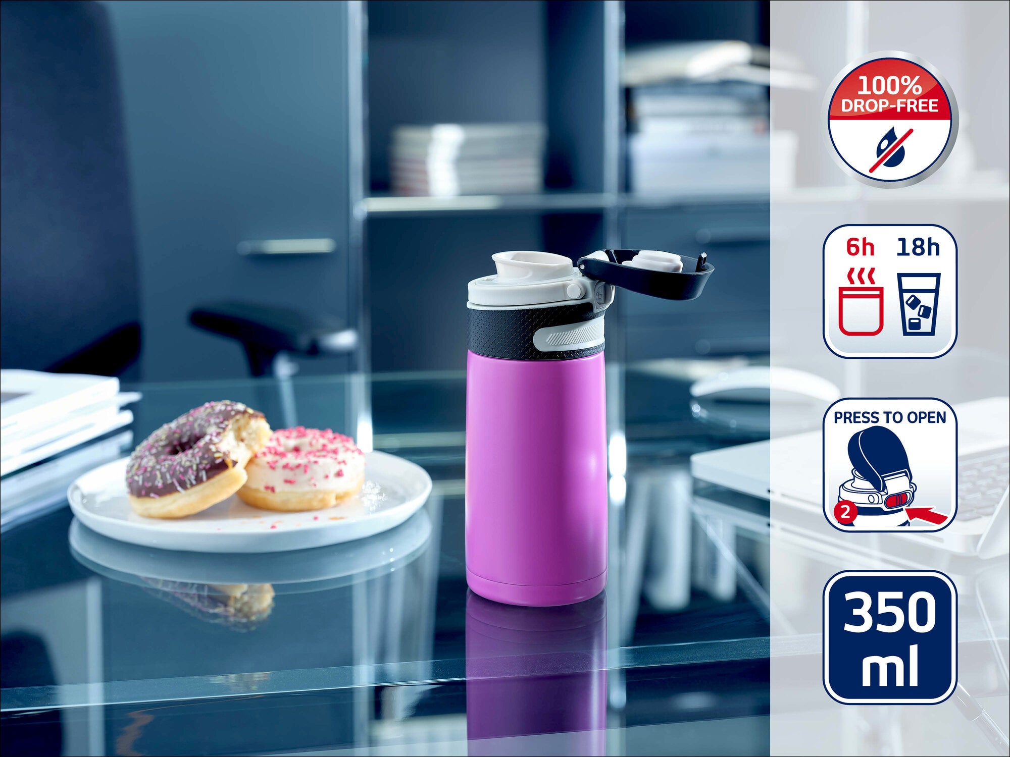 Leifheit Isolierbecher Flip 350 ml in Pink auf einem Glastisch im Büro neben einem Teller mit zwei Donuts; Seitenicons zeigen 100 % auslaufsicher, 6 h heiß, 18 h kalt und Deckel per Knopfdruck zu öffnen.
