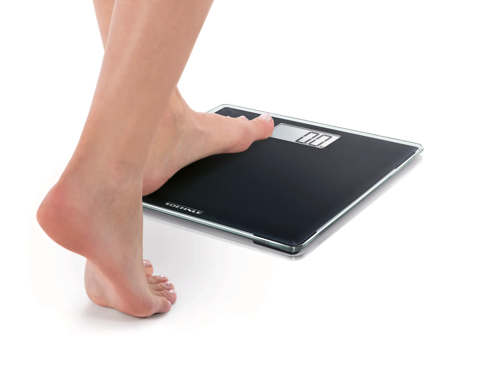 Eine Person steht mit einem Fuß auf einer digitalen Personenwaage, Modell Style Sense Compact 100. Die Waage hat ein modernes, schlankes Design und zeigt das Gewicht auf einem klaren Display an.