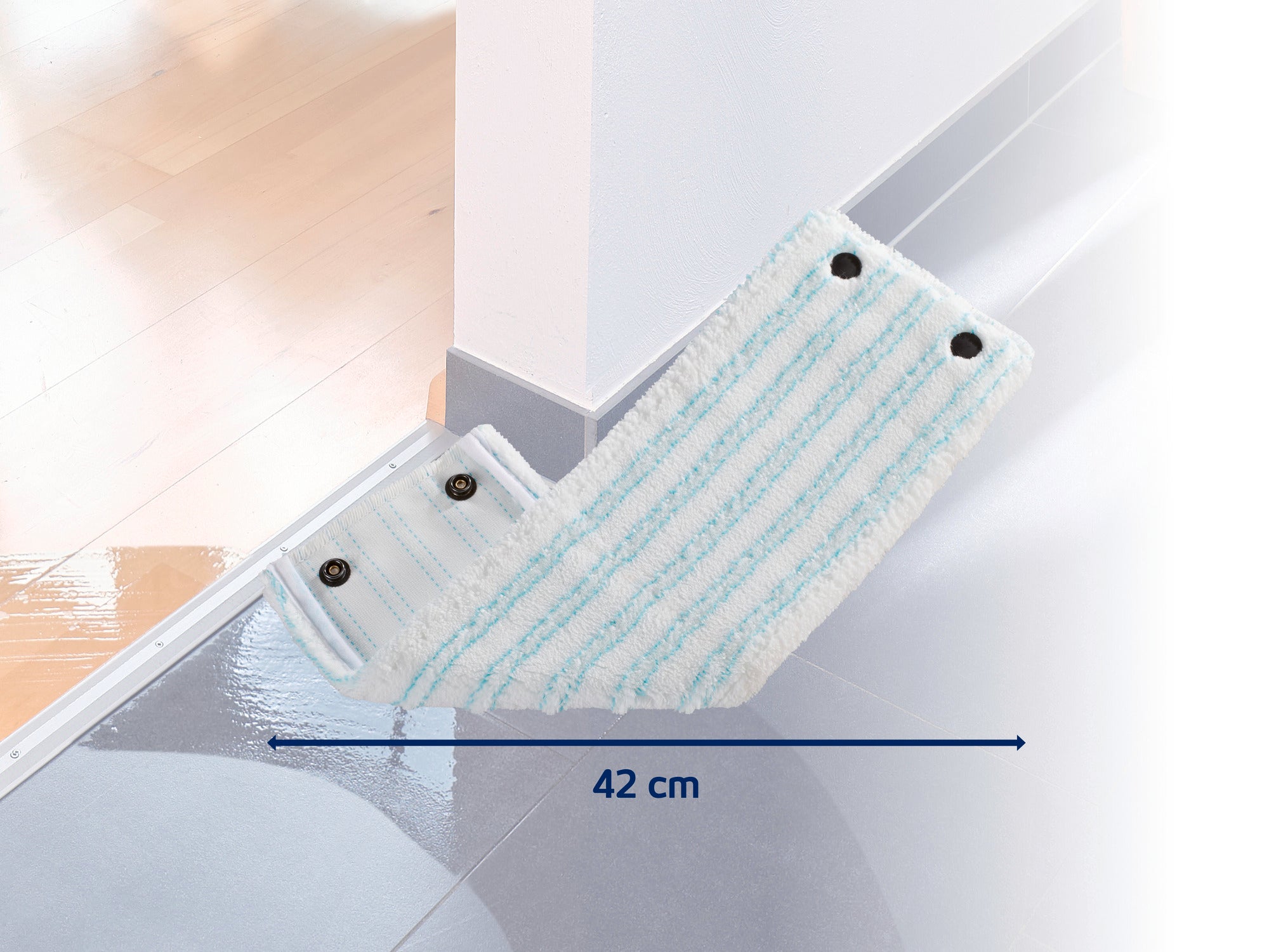 Ein weiß-blauer Wischmopp-Aufsatz mit einer Breite von 42 cm liegt auf einem glänzenden Boden. Der Aufsatz hat vier schwarze Druckknöpfe und ist ideal für die gründliche Reinigung von Ecken.