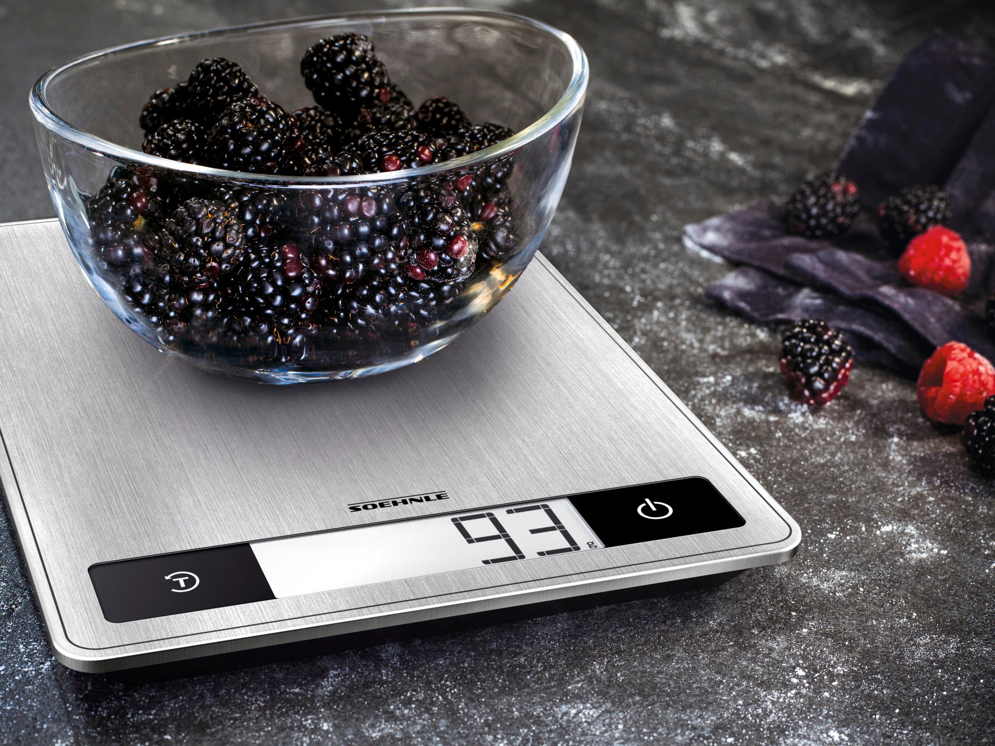 Digitale Küchenwaage Page Profi 200 mit einer Schüssel voller Brombeeren auf einer dunklen Arbeitsfläche. Die Waage zeigt ein Gewicht von 93 Gramm an. Ideal für präzises Wiegen in der Küche.