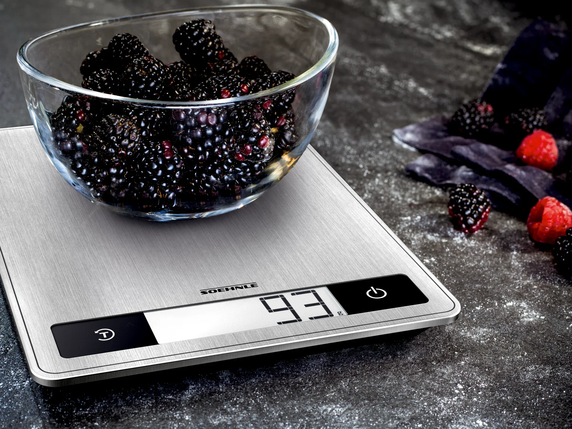 Digitale Küchenwaage Page Profi 200 mit einer Schüssel voller Brombeeren auf einer dunklen Arbeitsfläche. Die Waage zeigt ein Gewicht von 93 Gramm an. Ideal für präzises Wiegen in der Küche.