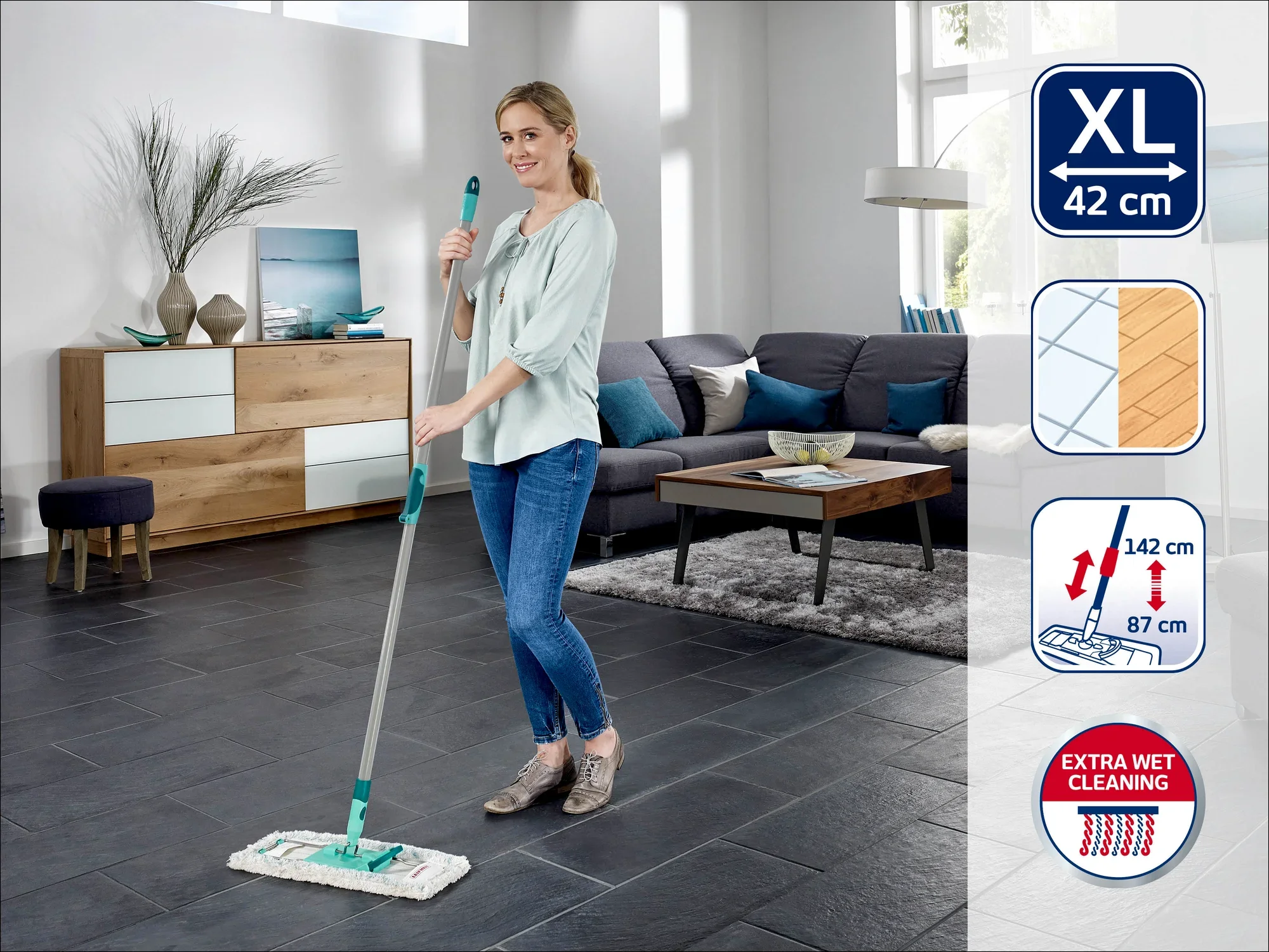 Eine Frau wischt den Boden in einem modernen Wohnzimmer mit einem Leifheit Bodenwischer XL, 42 cm. Der Wischer hat einen Teleskopstiel, der von 87 cm bis 142 cm verstellbar ist, und bietet eine extra feuchte Reinigung.