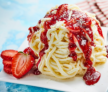 Spaghetti Eis Ein Spaghetti-Eis mit Erdbeersosse und Puderzucker, garniert mit einer halben Erdbeere auf einem Teller.