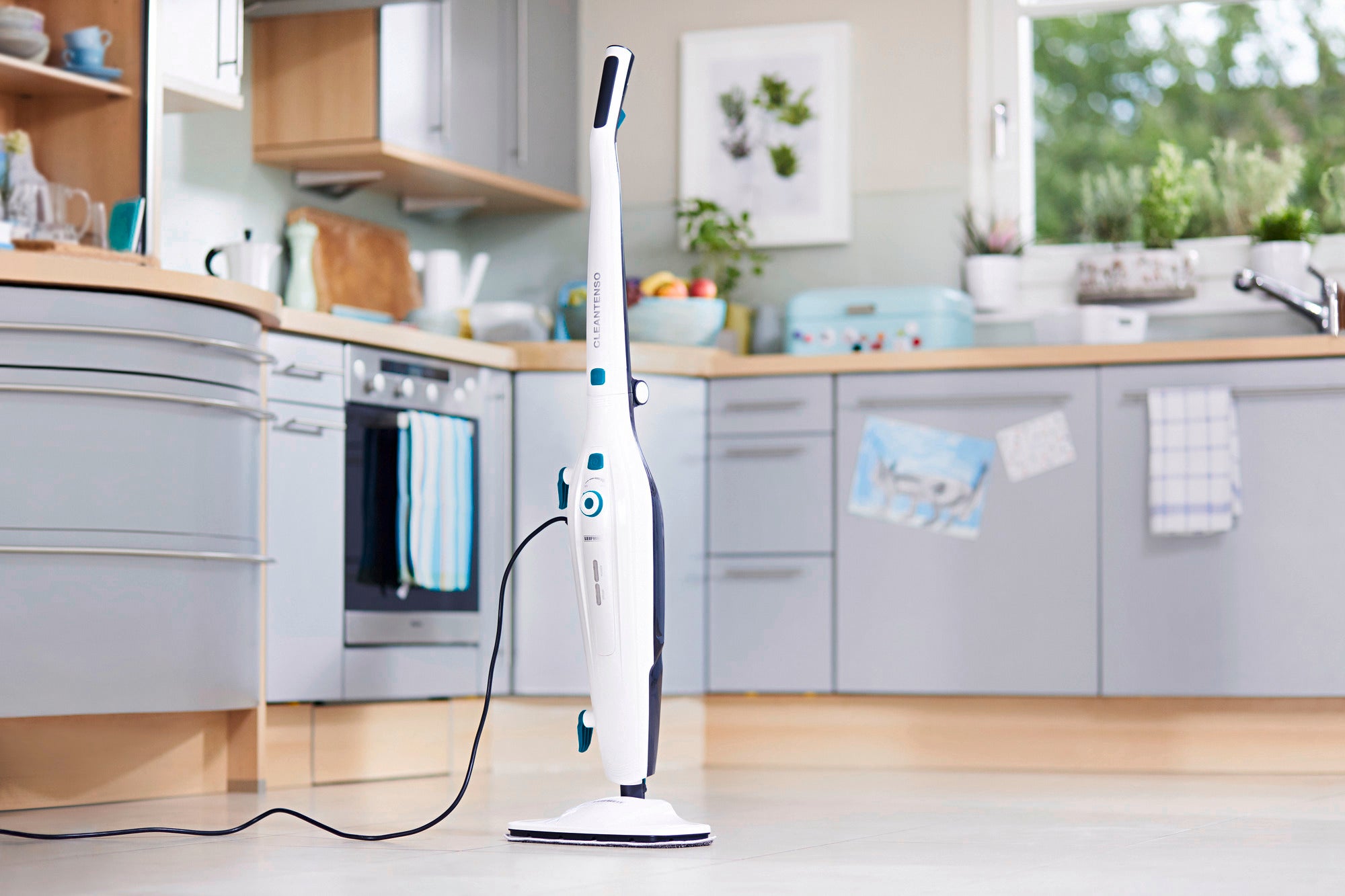 Dampfreiniger Clean Tenso steht in einer modernen Küche mit hellen Schränken und großen Fenstern. Das Gerät ist schlank und weiß, ideal für gründliche Reinigung.