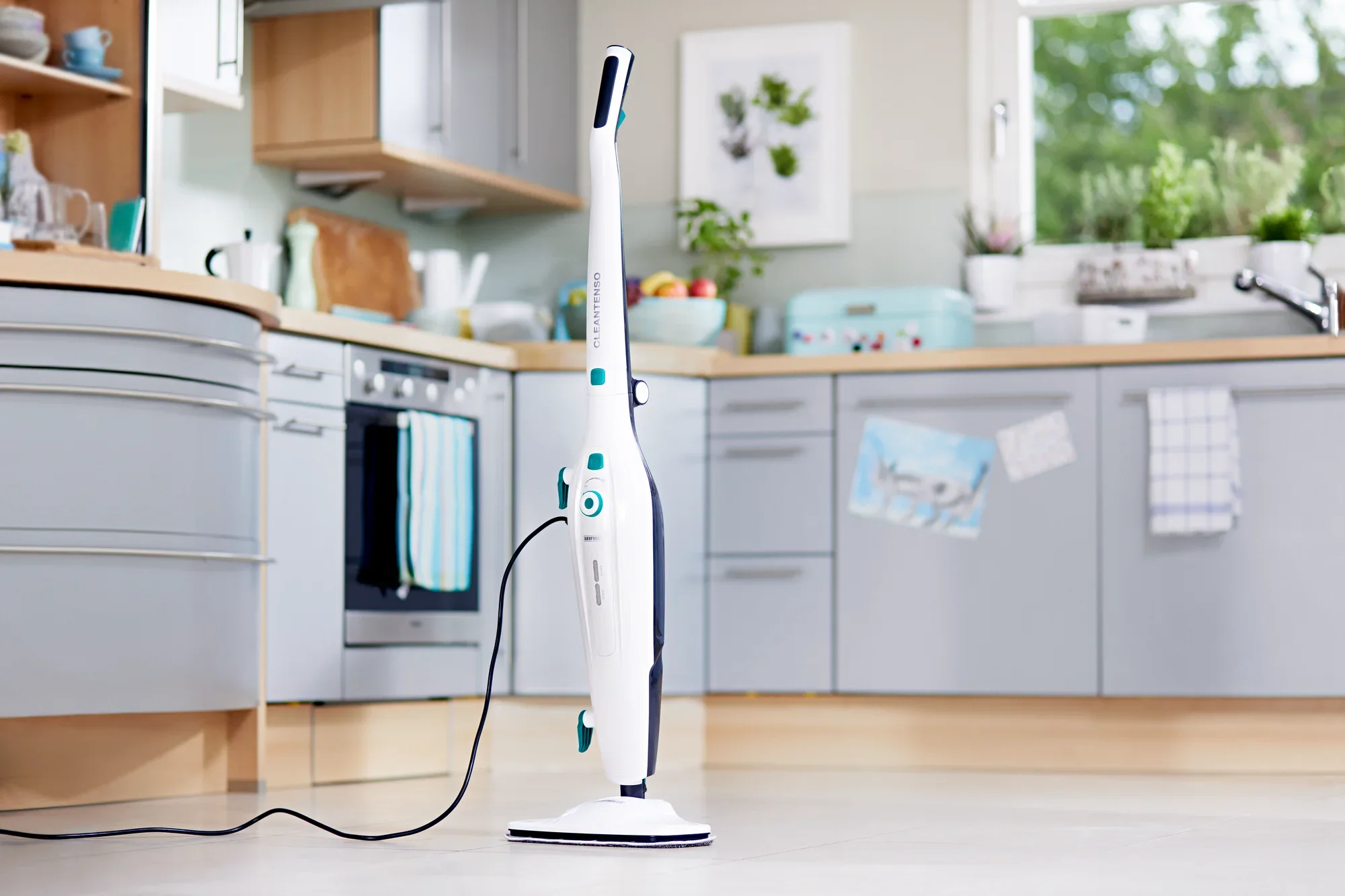 Dampfreiniger Clean Tenso steht in einer modernen Küche mit hellen Schränken und großen Fenstern. Das Gerät ist schlank und weiß, ideal für gründliche Reinigung.