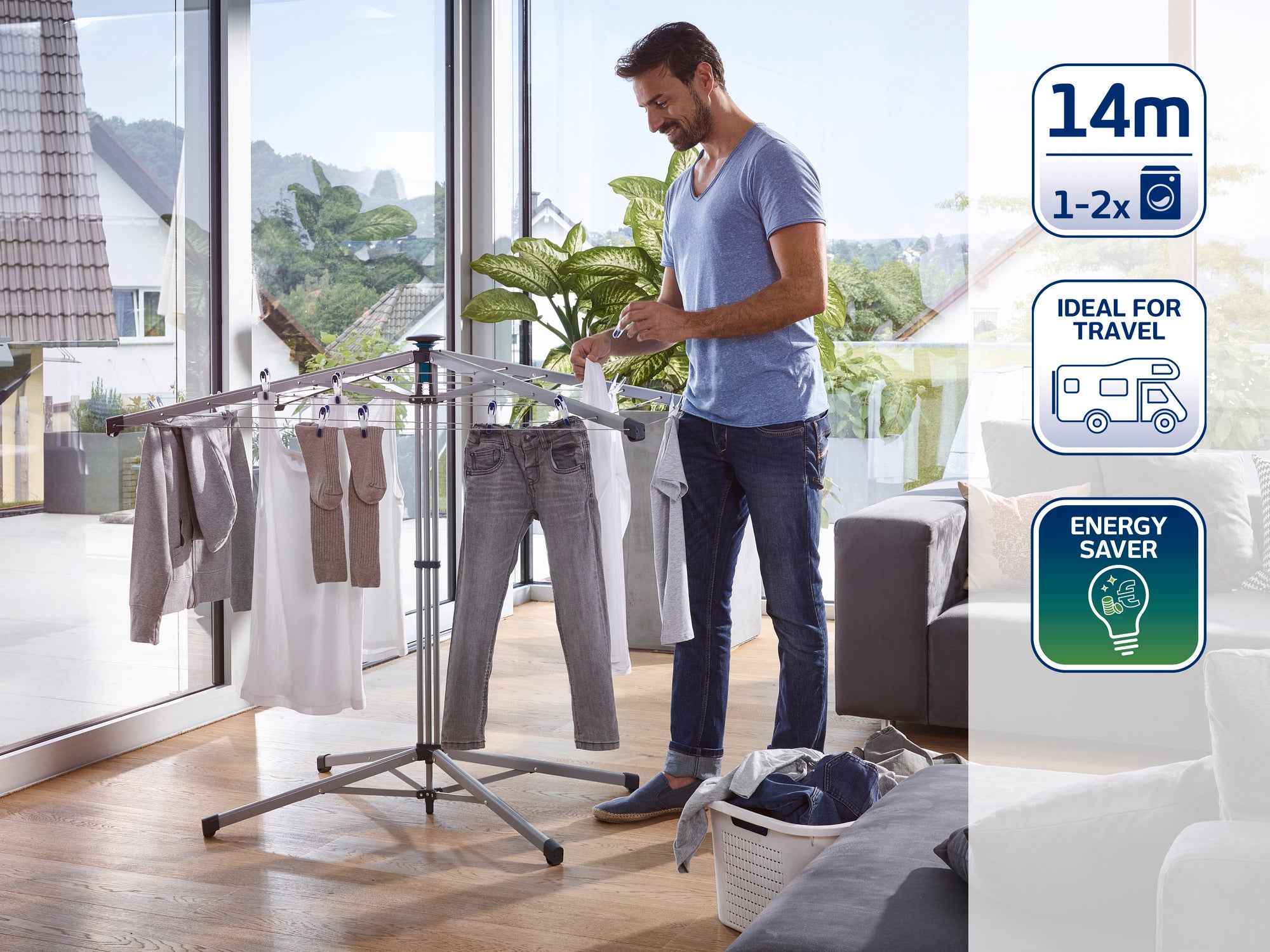 Ein Mann steht in einem modernen Wohnzimmer und nutzt eine Wäschespinne zum Trocknen von Kleidung. Die Wäschespinne ist kompakt und ideal für Reisen geeignet. Sie spart Energie und bietet Platz für bis zu 14 Meter Wäsche.