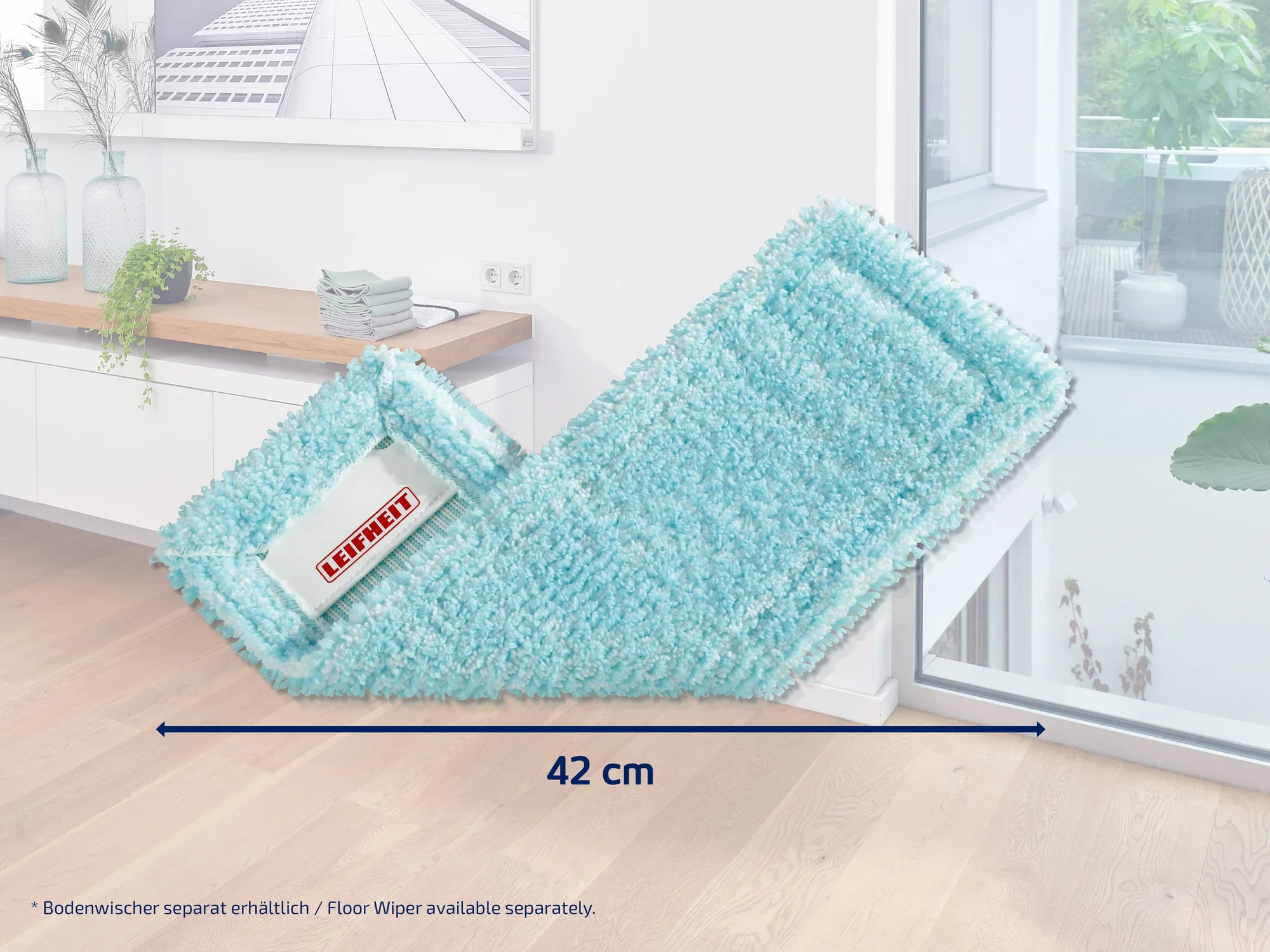 Un accessorio per lavapavimenti da pavimento turchese del marchio Leifheit, largo 42 cm, si trova in una stanza moderna e luminosa con pavimento in legno e grandi finestre. Perfetto per una pulizia efficiente.