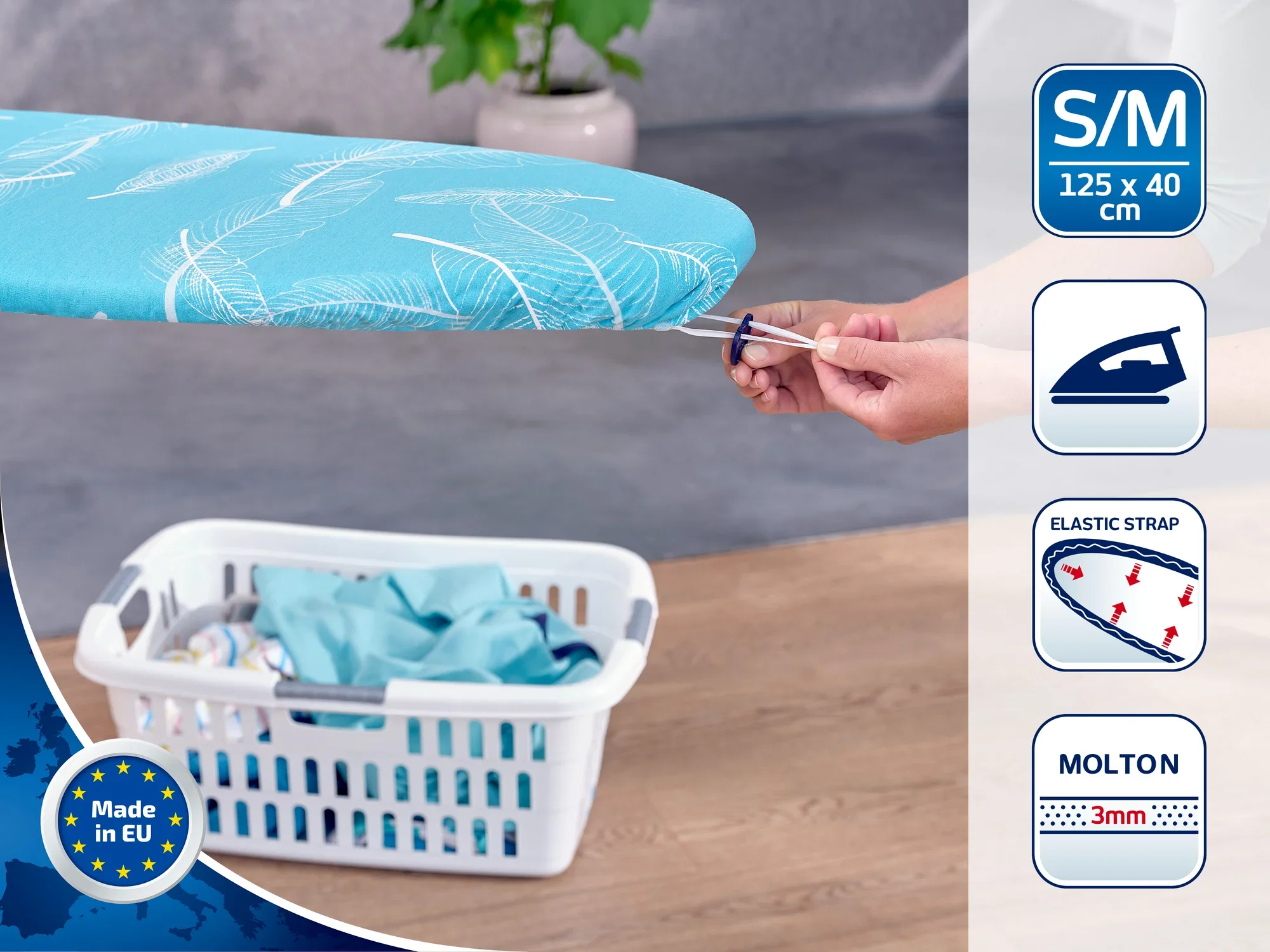 Une housse de table à repasser bleue avec des motifs blancs est tendue sur une table à repasser. La housse est disponible en taille S/M (125 x 40 cm) et dispose d'une sangle élastique. Fabriquée en UE.