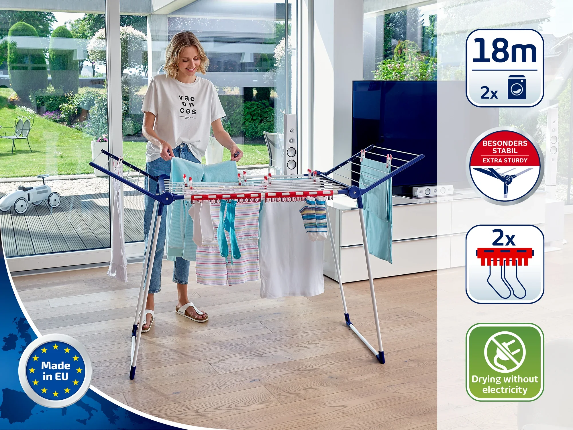 Kobieta korzysta z suszarki stojącej w nowoczesnym salonie. Suszarka oferuje 18 metrów długości suszenia i jest wyjątkowo stabilna. Suszy ubrania bez użycia energii elektrycznej i jest produkowana w UE.