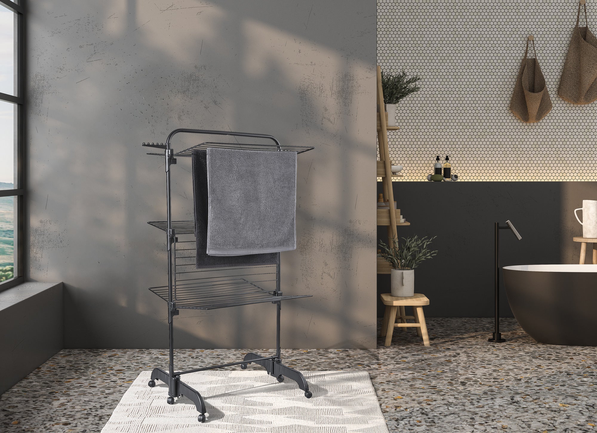 A Comfort Tower 420 Black tower dryer stands in a modern bathroom. The dryer is equipped with a grey towel and fits perfectly with the stylish interior.