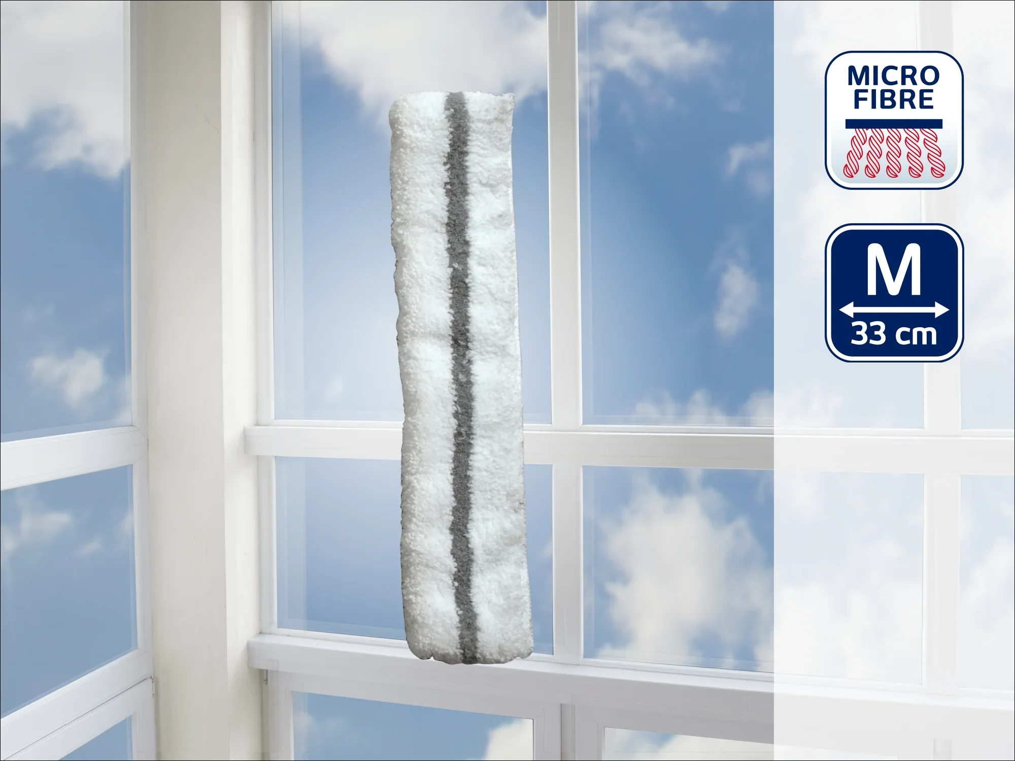Een witte microvezel raamwisser met een grijze streep, maat M, 33 cm lang, hangt voor een raam. Op de achtergrond is een blauwe lucht met wolken te zien.