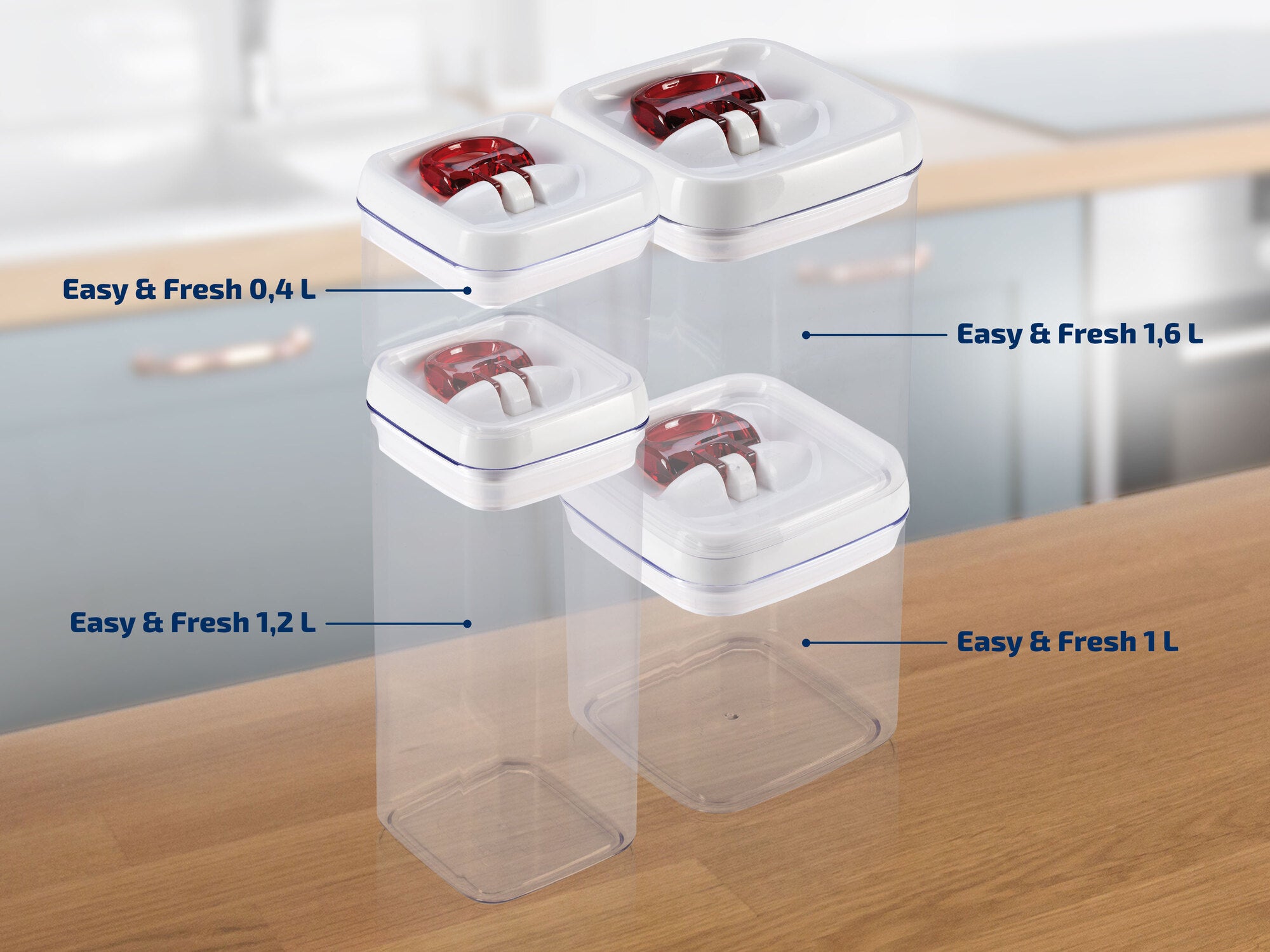 Quatre boîtes empilables transparentes Easy & Fresh de différentes tailles (0,4 L, 1 L, 1,2 L, 1,6 L) avec couvercles blancs et fermetures rouges, posées sur un plan de travail de cuisine.