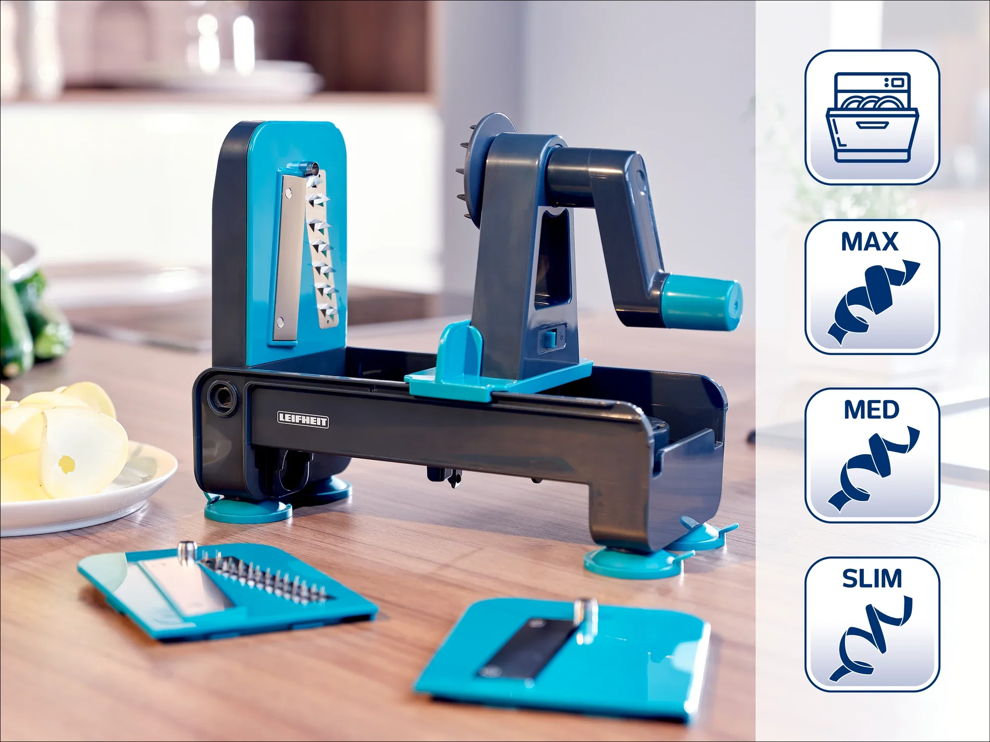 Ein Spiralschneider von Leifheit auf einer Küchenarbeitsplatte. Er hat verschiedene Klingen für unterschiedliche Schnittstärken: MAX, MED und SLIM. Ideal zum Schneiden von Gemüse in Spiralen.