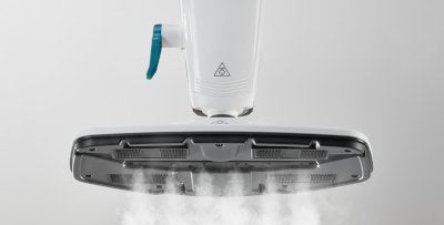 Ein weisser Dampfreiniger mit blauem Griff stoesst starken Dampf aus der breiten Duese gegen einen grauen, neutralen Hintergrund aus.