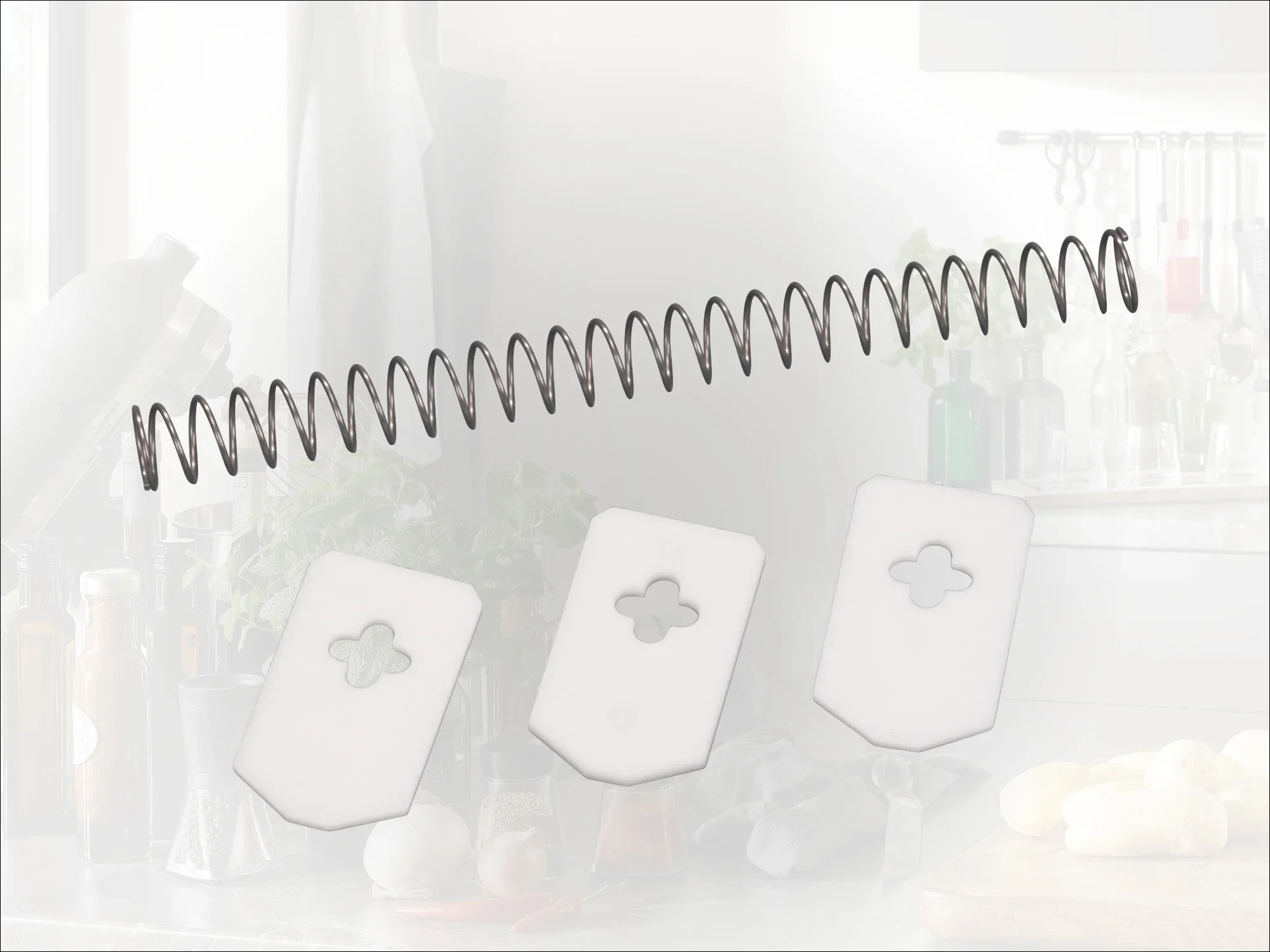 Ein Set von drei weißen Kunststoffklingen mit einem spiralförmigen Metallfederaufsatz. Die Klingen haben ein dekoratives Kleeblattmuster in der Mitte. Ideal für kreative Küchendekorationen.