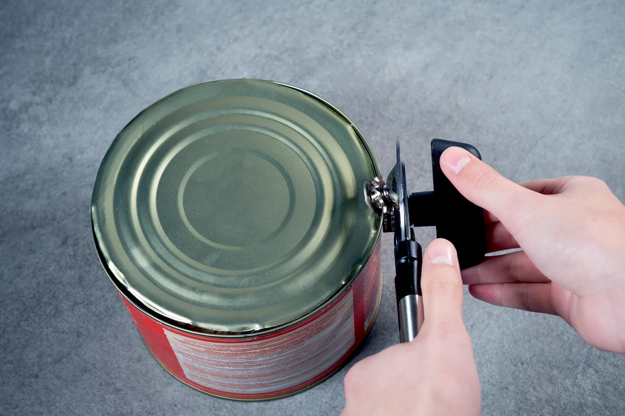 Otwieracz do puszek jest używany do otwierania dużych puszek. Dwie ręce trzymają otwieracz do puszek, podczas gdy ostrze przecina wieczko.