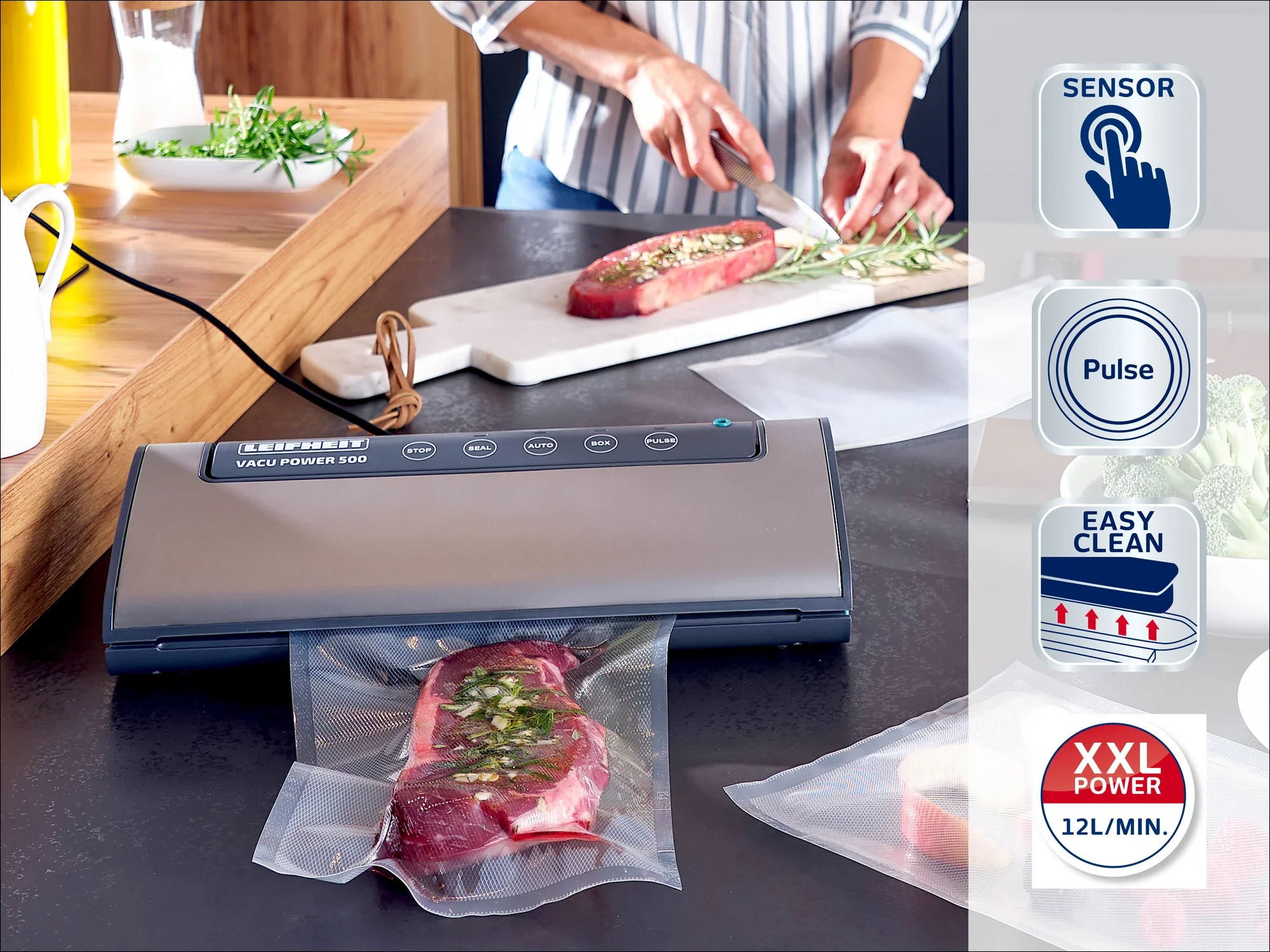 Zgrzewarka próżniowa Leifheit na blacie kuchennym. Osoba kroi mięso, podczas gdy inny kawałek jest zgrzewany próżniowo. Symbole pokazują czujnik, funkcję pulsu, łatwe czyszczenie i moc XXL.