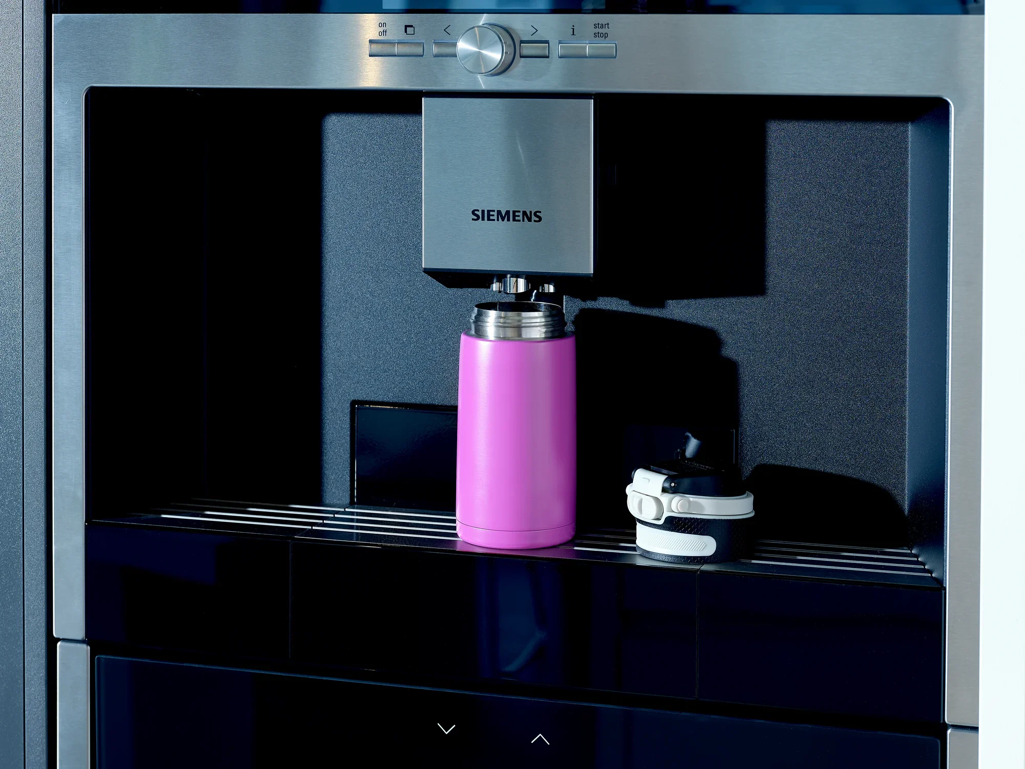 Izolowany kubek Flip 350 ml w kolorze fioletowym stoi w nowoczesnym ekspresie do kawy. Kubek ma zdejmowaną pokrywkę i jest idealny do utrzymywania ciepła napojów podczas podróży.