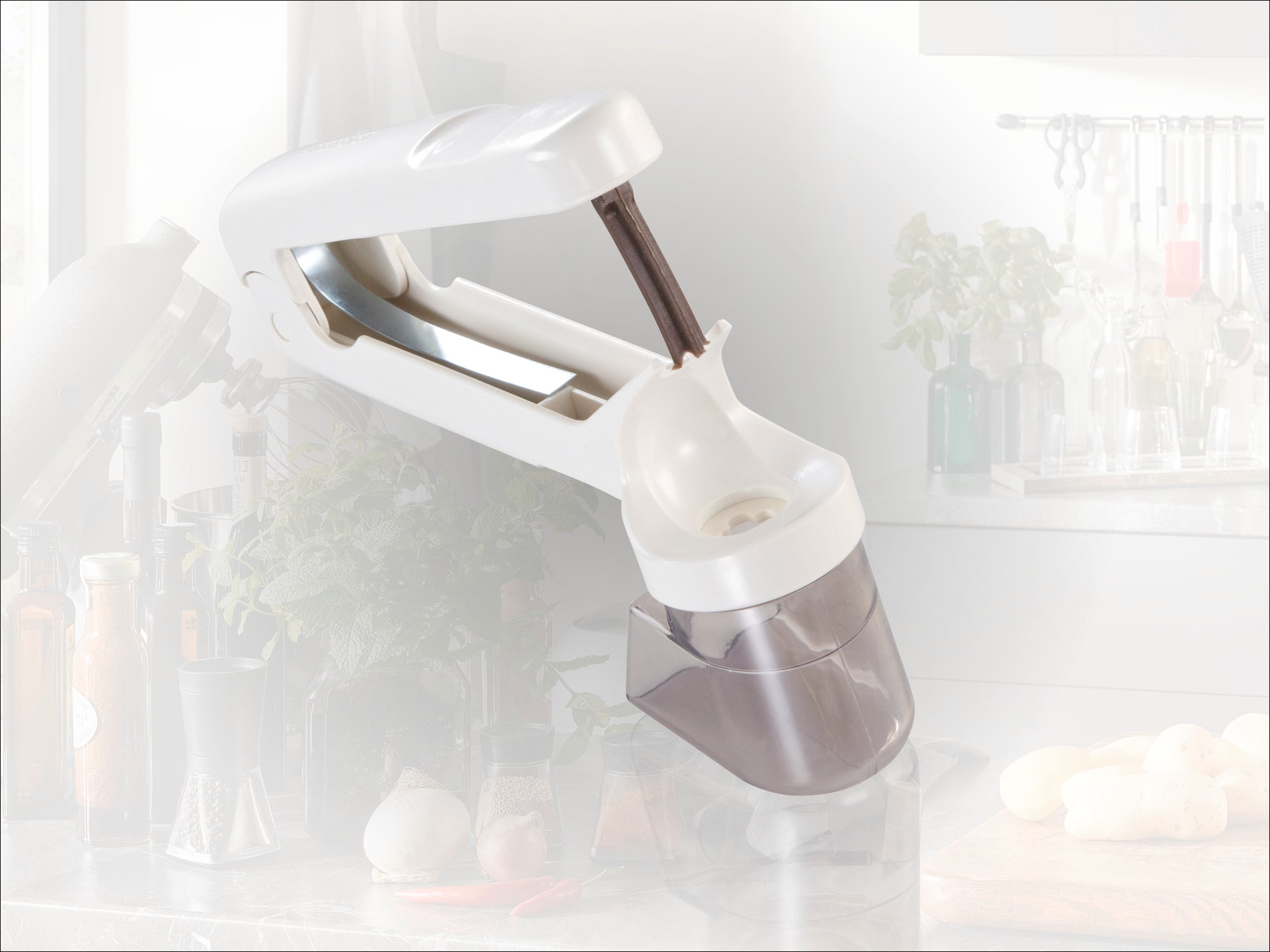 Un coupe-ail blanc avec une poignée ergonomique et un récipient transparent. Idéal pour préparer rapidement et facilement de l'ail frais dans la cuisine.