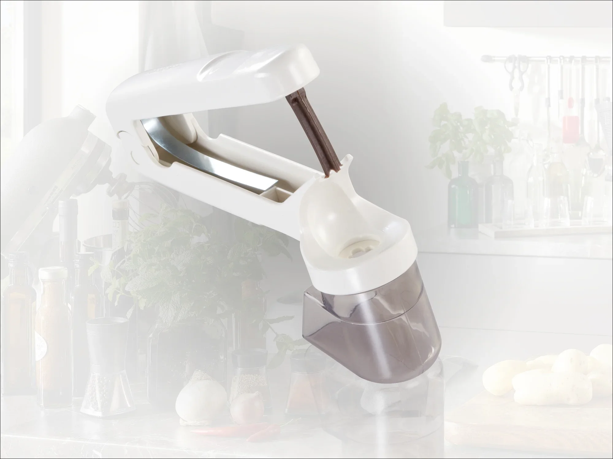 A white garlic cutter with an ergonomic handle and transparent collection container. Ideal for quickly and easily preparing fresh garlic in the kitchen.