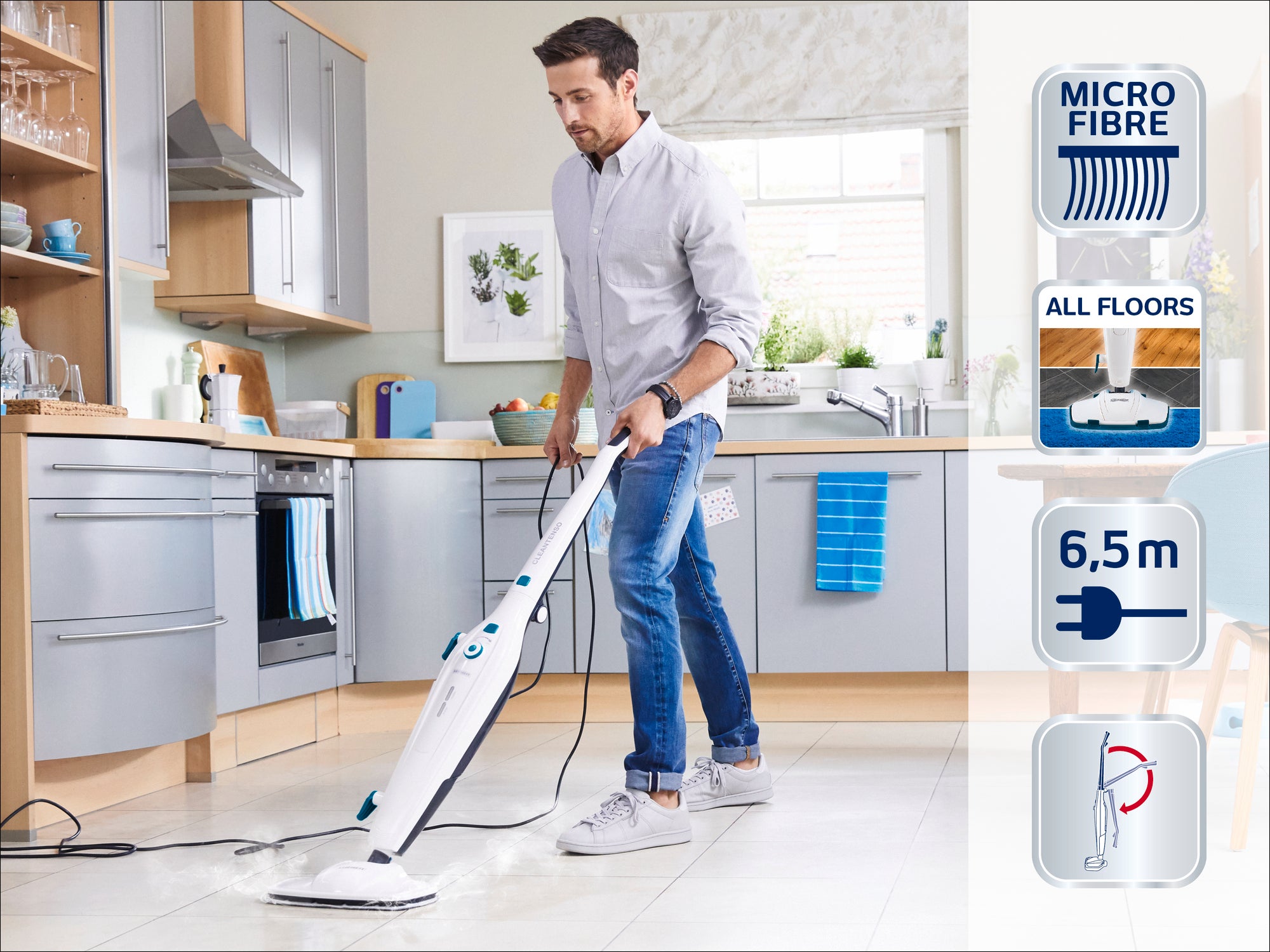 Ein Mann reinigt den Küchenboden mit einem Dampfreiniger. Der Dampfreiniger hat ein Mikrofasertuch, ist für alle Bodenarten geeignet und hat ein 6,5 m langes Kabel.
