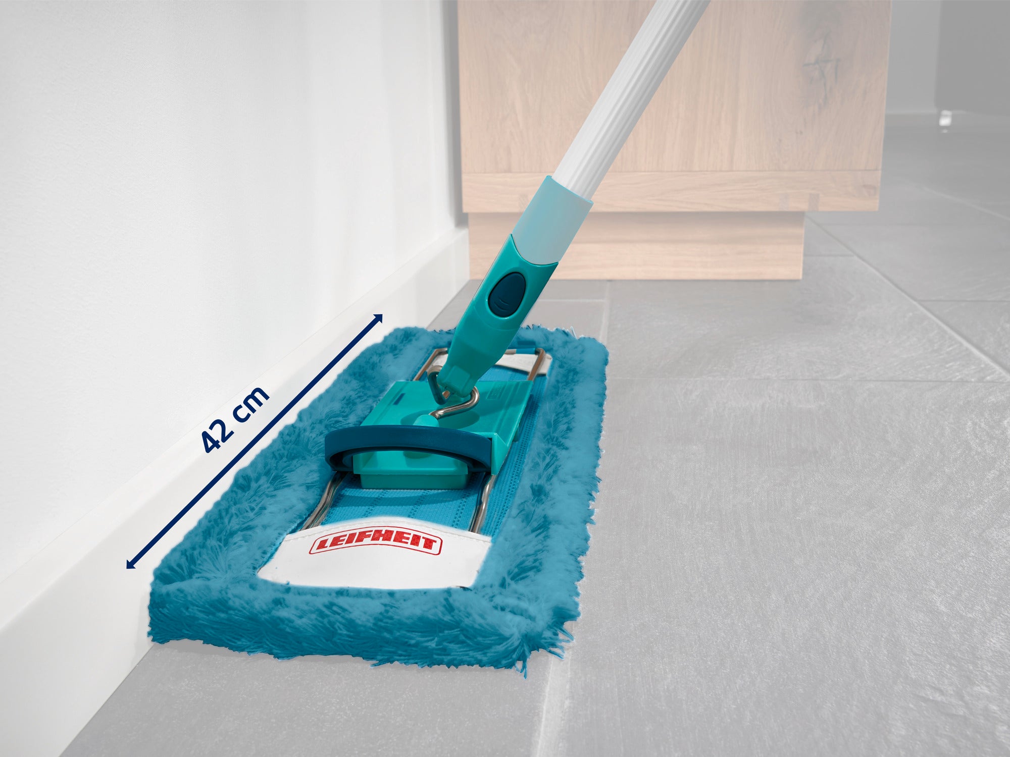 Urządzenie czyszczące z głowicą mopa o szerokości 42 cm, idealne do czyszczenia podłóg. Uchwyt jest ergonomicznie zaprojektowany, a na urządzeniu widnieje logo "Leifheit". Idealny do wydajnego mopowania.