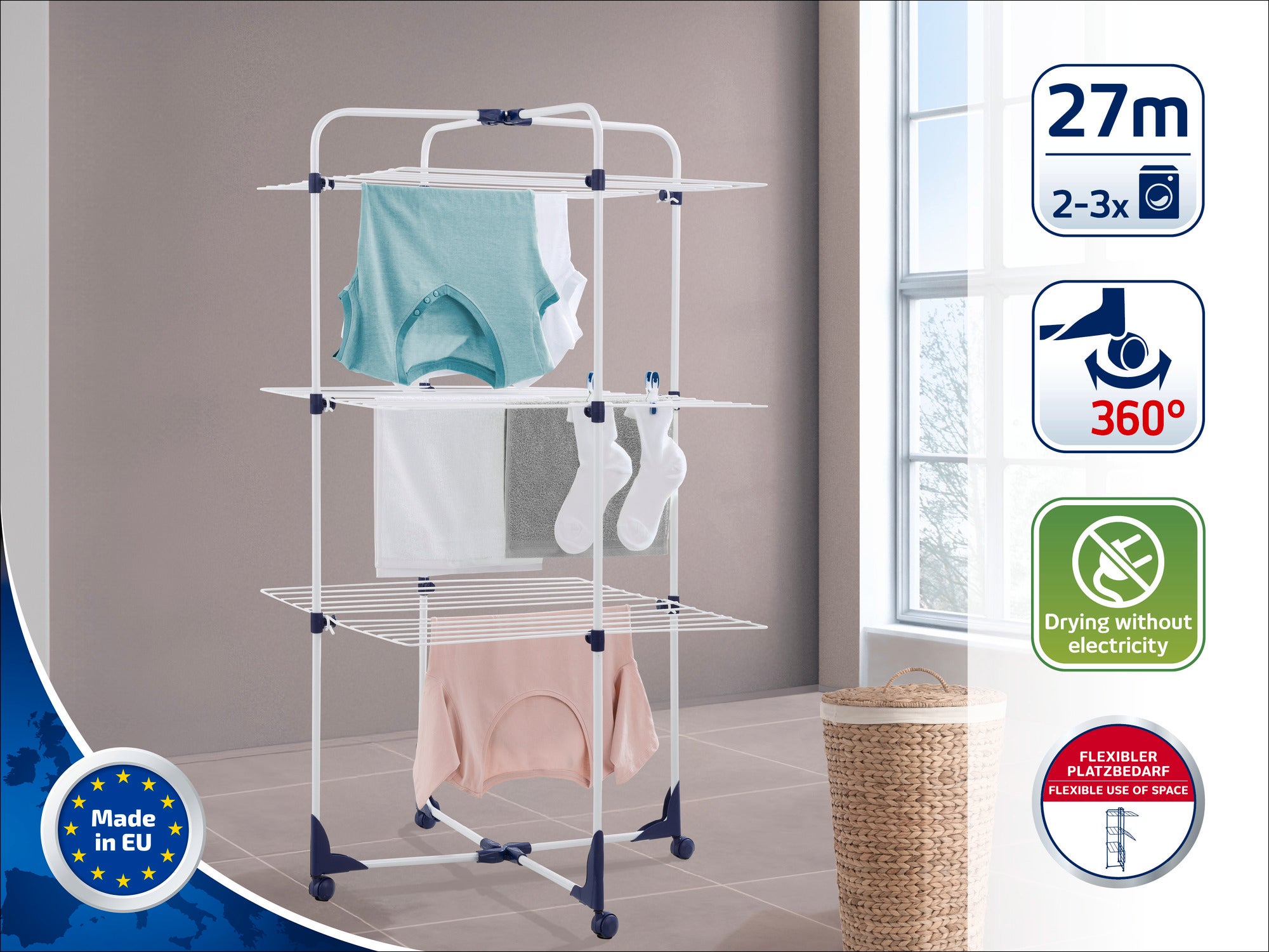 Een torendroger staat in een lichte kamer. Hij heeft verschillende niveaus voor het drogen van kleding. De labels geven een drooglengte aan van 27 meter, 360° rotatie en geen stroomverbruik.