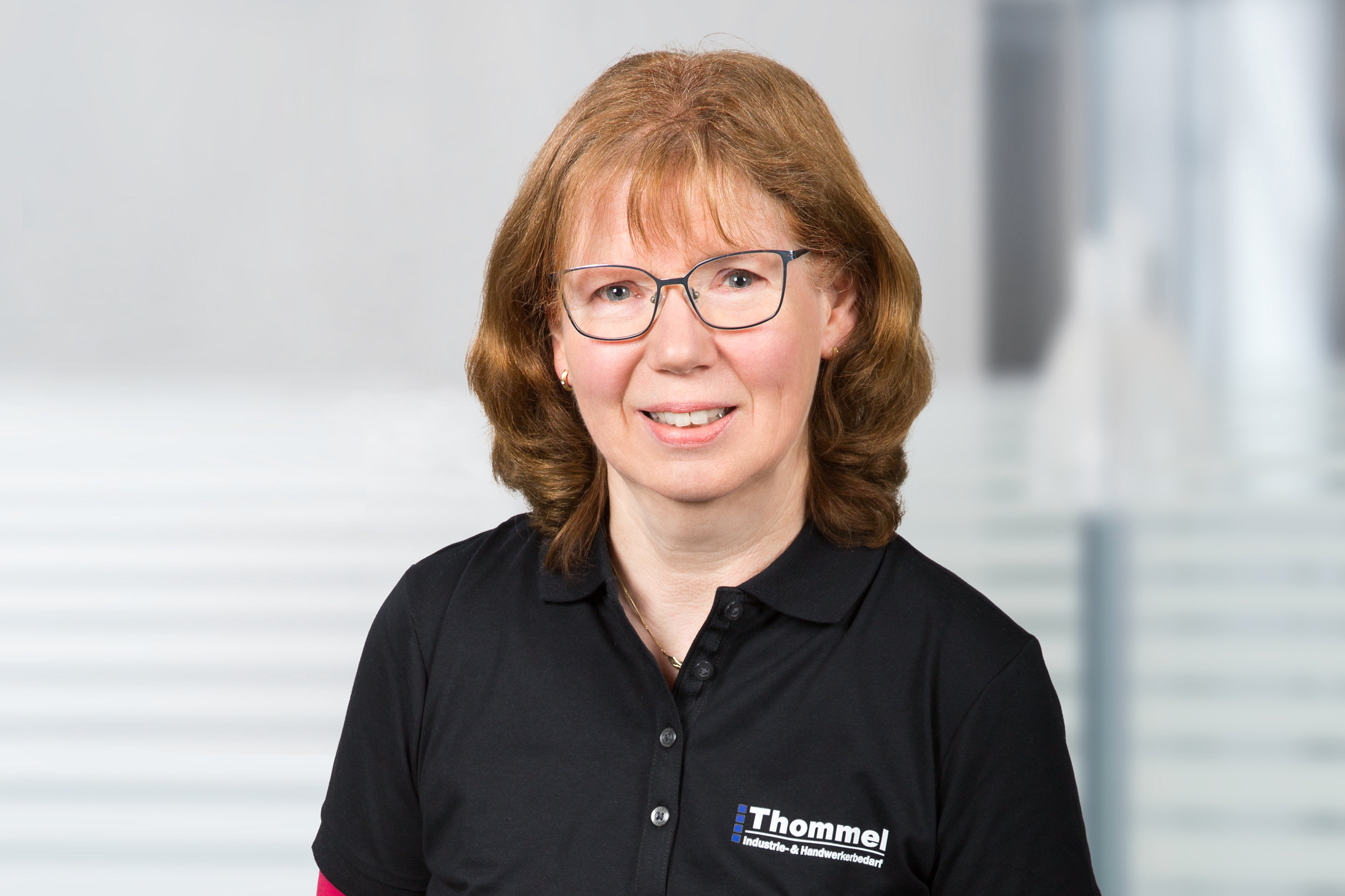 Portrait, Brille, schwarzes Polohemd, Mitarbeiter, Logo