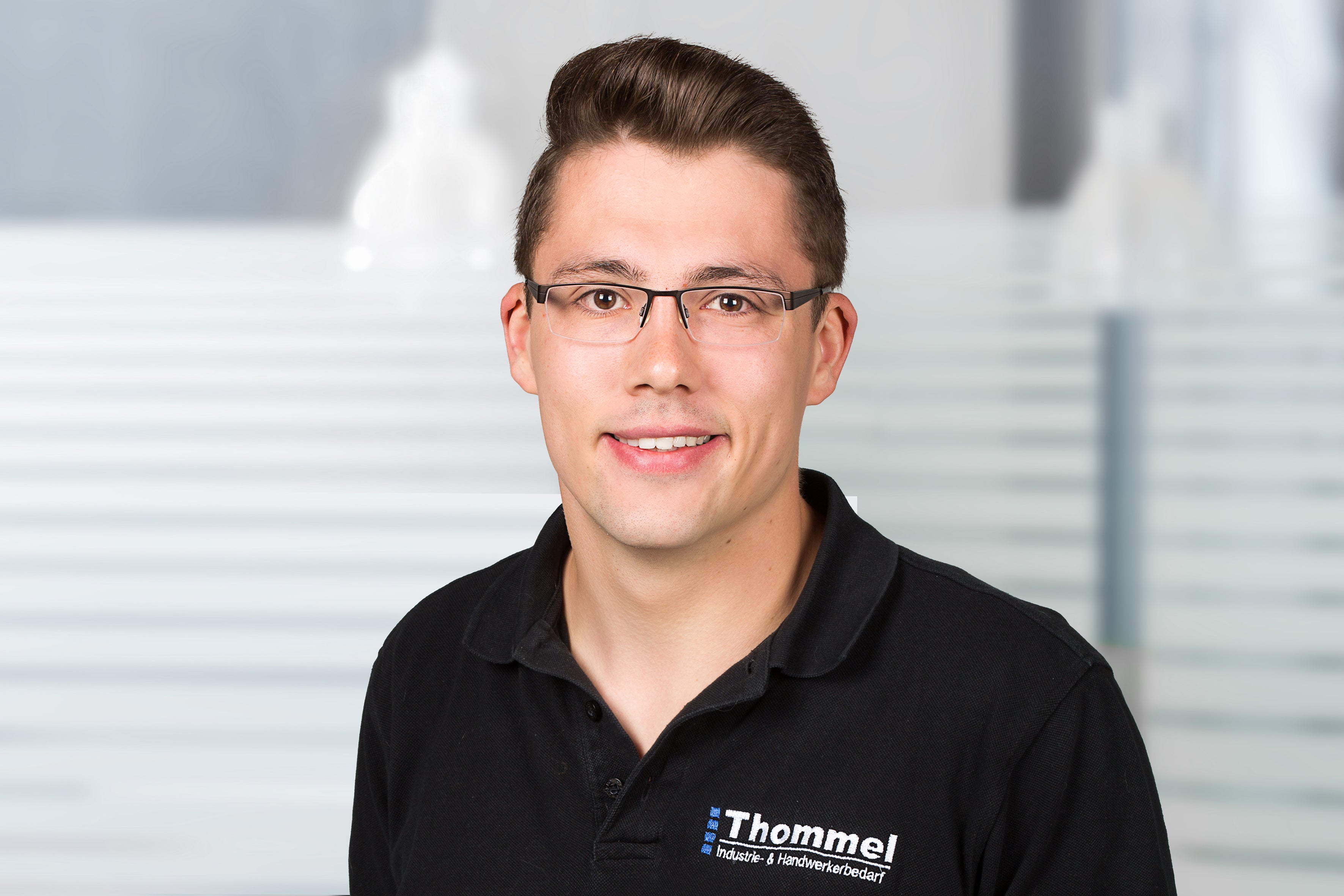 zahlensymbol, brille, schwarzes polohemd, glatt gestyhtes haar, thommel industrie- & handwerkerbedarf