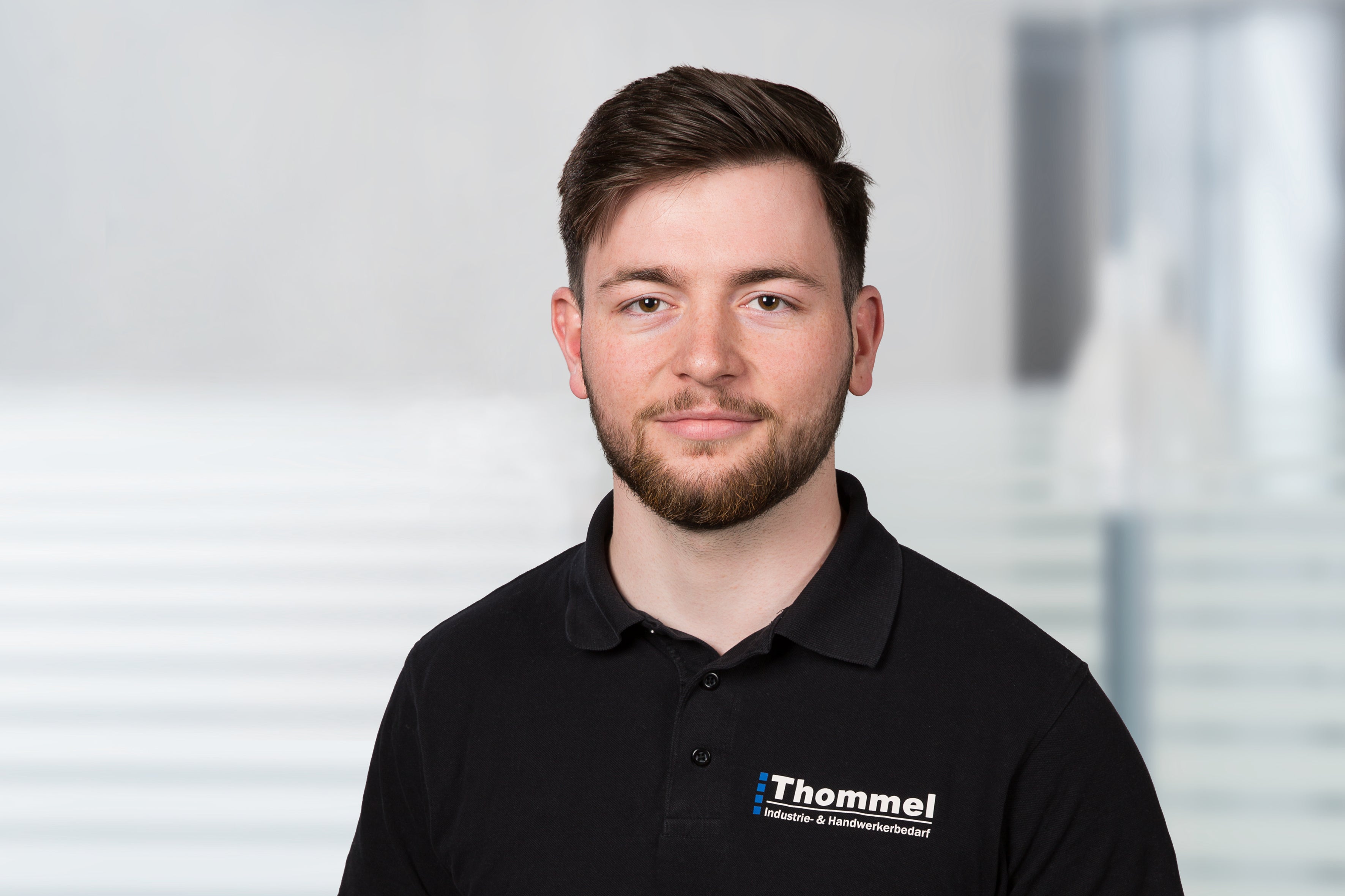 portrait, Mitarbeiter, schwarzes polohemd, Logo auf dem Hemd, Thommel