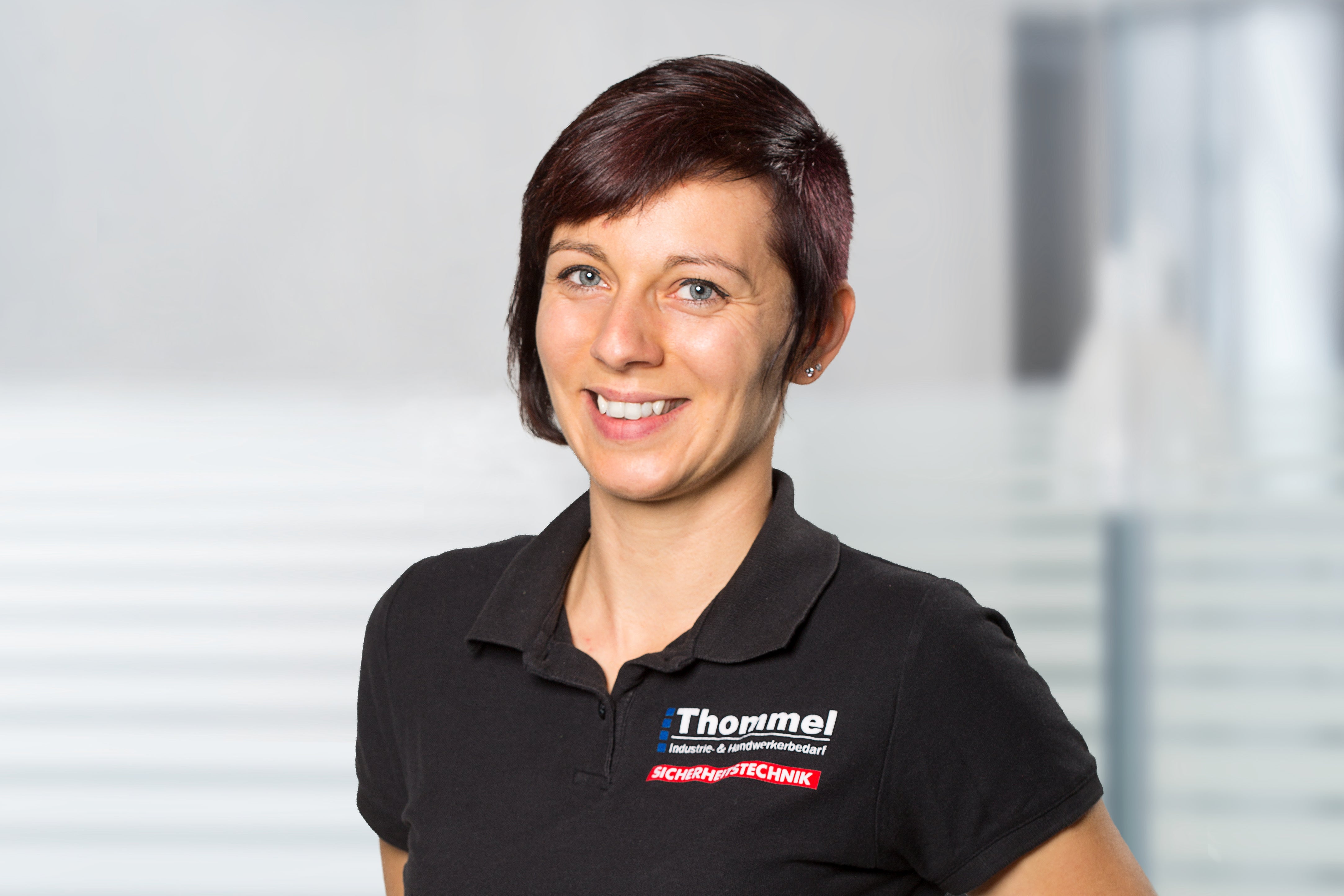 frau, schwarzes polohemd, kurze haare, mitarbeiterin, logo