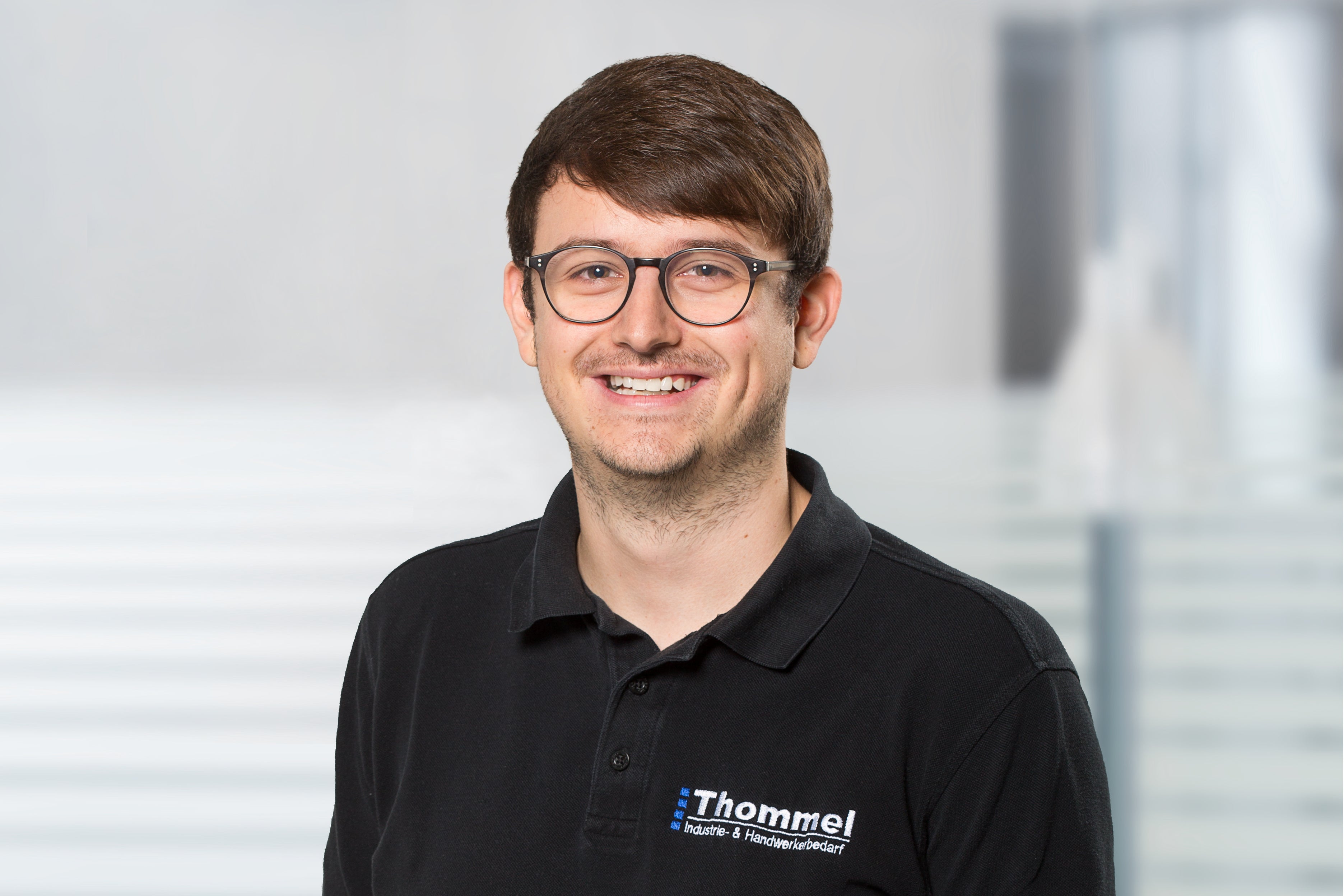 person, brille, schwarzes polohemd, logo, polo-shirt