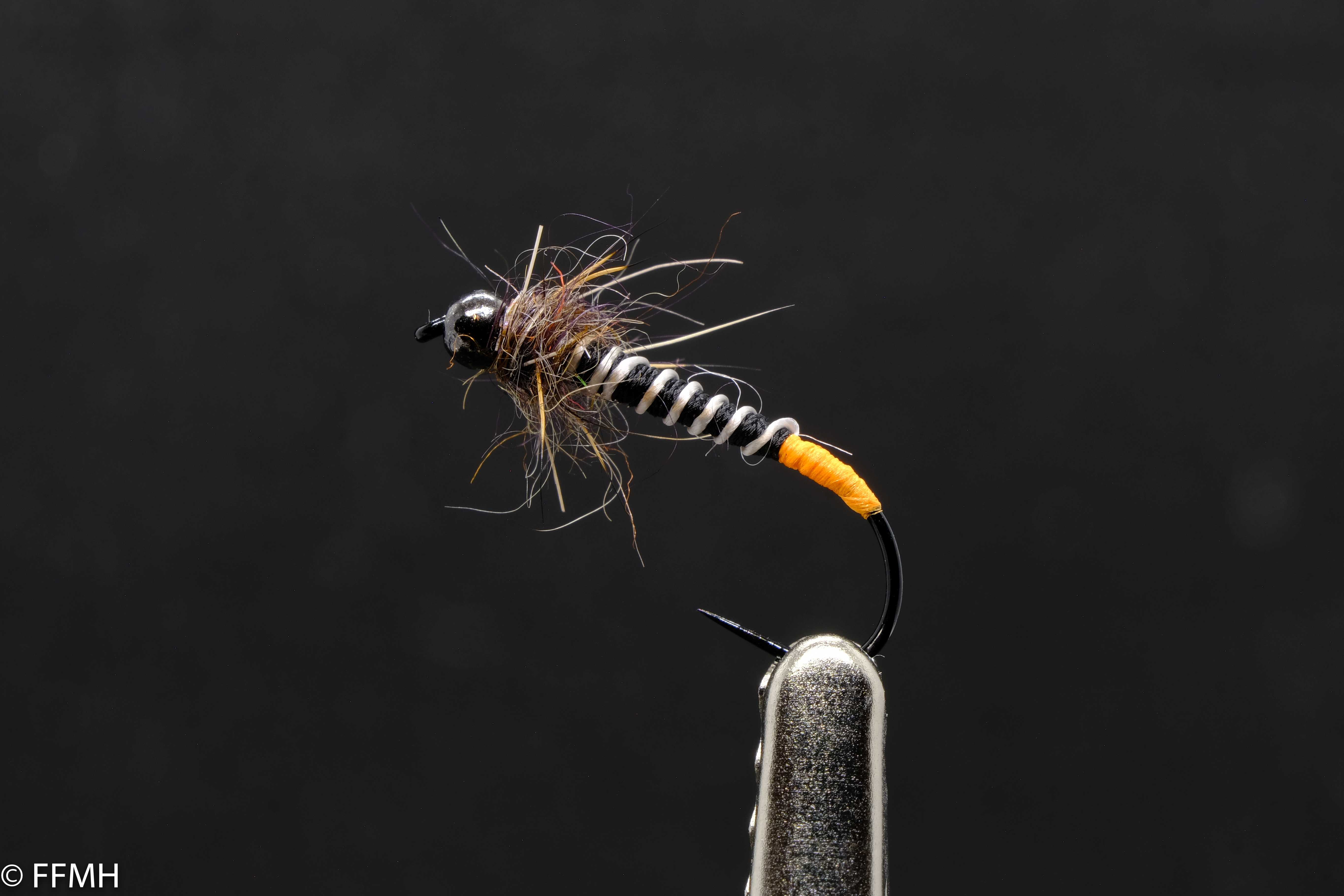 Black Head Hairy Orange Tail – kontrastreiche Nymphe mit natürlichem Spiel Black Head Hairy Orange Tail – handgebundene Nymphe mit schwarzem Perlenkopf, kontrastierendem, segmentiertem Körper, orangefarbenem Schwänzchen und buschigem Thorax, ideal für präzise Präsentationen in bewegtem Wasser