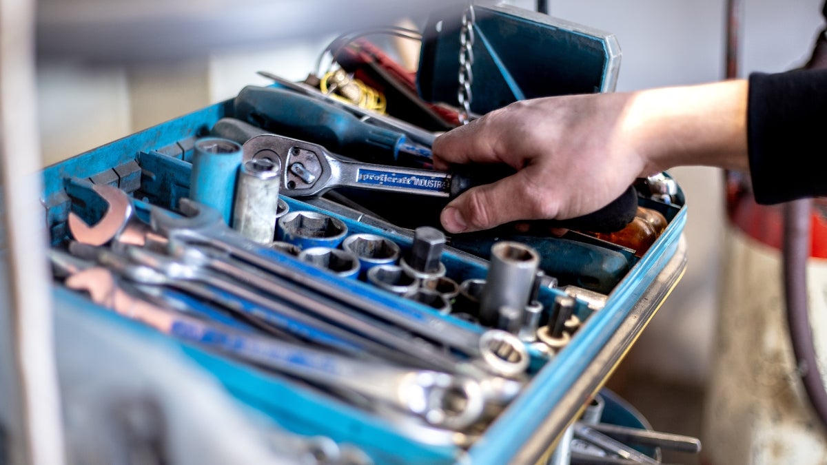 Servicetechniker greift in der eigenen Werkstatt zum Werkzeug